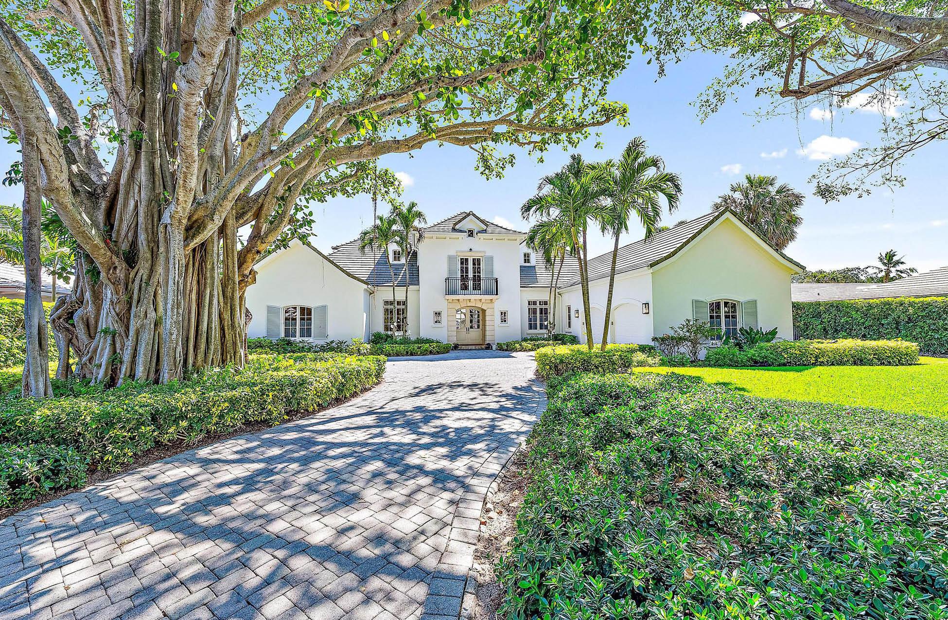 This exquisite golf course estate boasts breathtaking water views and unparalleled privacy. The property features a magnificent legacy tree and a grand entrance that sets the tone for the entire experience. Inside, you'll find soaring ceilings with elegant coffered designs, arched door frames, a modern fireplace, and french doors that enhance the sophisticated coastal style. An open and inviting floor plan includes 4 bedrooms and 4 full bathrooms plus 1 half bath. Abundant natural light floods in through numerous windows, illuminating the spacious kitchen and living areas. The expansive first-floor master suite provides direct access to the outdoor oasis and additional guest accommodations upstairs are each complete with a balcony for added luxury.