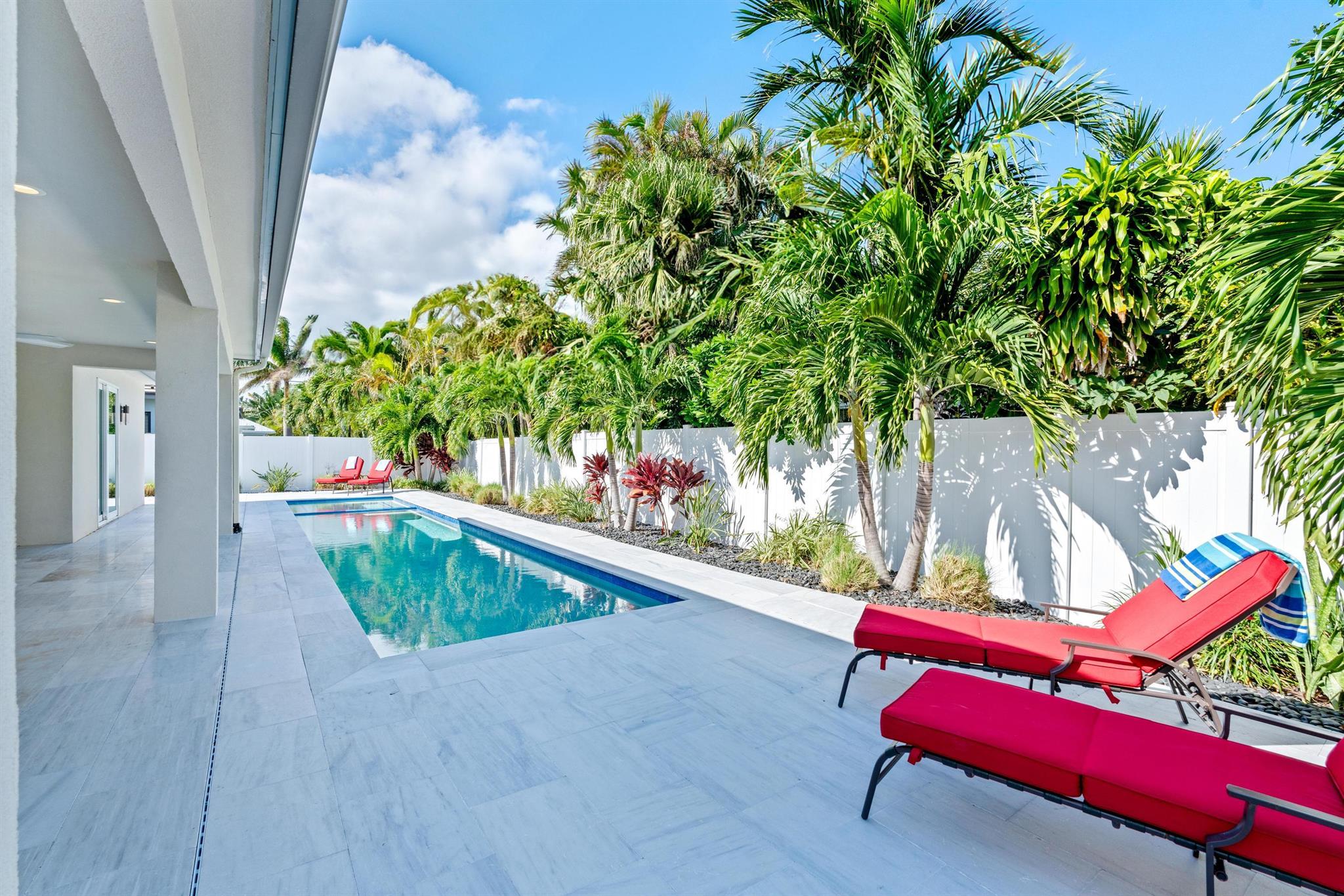 Stunning 2019 coastal contemporary home in Yacht Harbor Manor! This 3BD/3.5BA + bonus room gem offers high-end finishes, tropical low-maintenance landscaping, and a resort-style lap pool, hot tub, and outdoor shower. Enjoy the Italian marble pool deck, gas hookup for an outdoor kitchen, and beach Access by Easement --all with a low HOA and flexible rental rules. Inside, find engineered hardwood floors, solid core doors, 10' ceilings, a chef's kitchen with quartz counters, GE Monogram appliances, and a 6-burner gas stove. The spacious master suite boasts a custom walk-in closet and luxurious bath with a soaking tub and walk-in shower. Just steps to Singer Island's pristine beach and 20 minutes to PBIA, this move-in-ready retreat is your ultimate Florida escape!