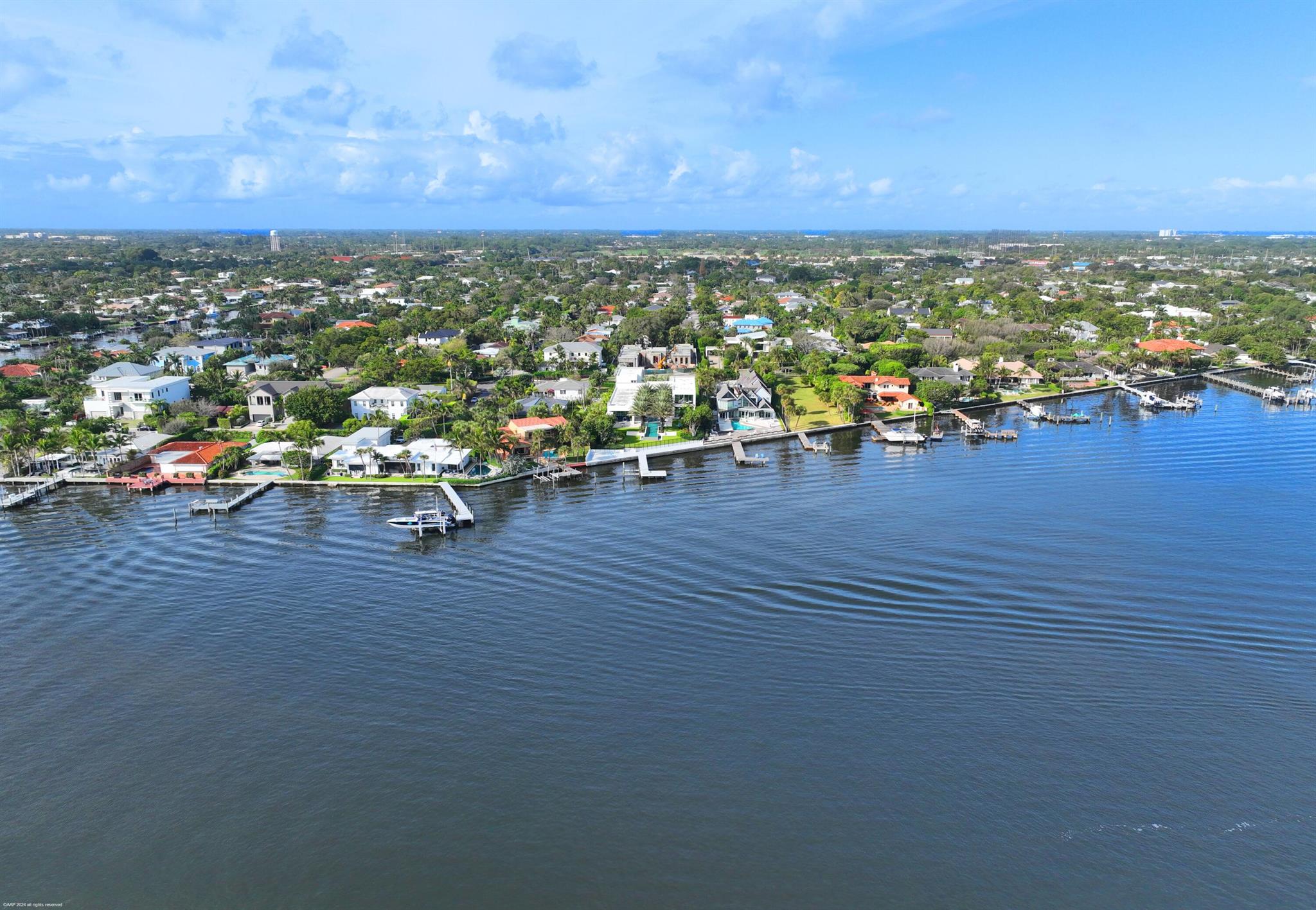 From the moment you enter the gates of this massive direct Intracoastal waterfront estate, you will experience first hand the hundreds of hours of inspiration and design by famed and respected architect George Brewer. His vision coupled with the direction and inspiration from the owners' decades of world travels have created this stunning modern masterpiece that was completed in 2021. Water is the main focus as you experience it throughout this nearly one acre property. From the front entrance and its cascading fountains, to the walls of glass that frame the entire eastern elevation of the home showcasing the massive resort style pool and turfed courtyard including a unique acrylic heated spa actually sitting in the water, to the expansive Intracoastal waterfront that has one of the largest, if not the largest, over the water deck and boat dock's in SoSo.  This provides the most spectacular long water views of downtown West Palm Beach you'll experience. 
The primary suite overlooks all this incredible beauty boasting a Worth Avenue boutique sized closet and a bath that lacks nothing.
The SOTArt gourmet kitchen has two huge islands and is loaded with everything needed to entertain family, friends and guests.
The fabulous design includes an elevator, an office, a warehouse sized refrigerated wine cooler, a very gracious and private guest apartment, an oversized 3 car garage, an outdoor kitchen and incredible covered outdoor dining and relaxation spaces. Finally, the decorative paved auto courtyard has room for over 20 cars.