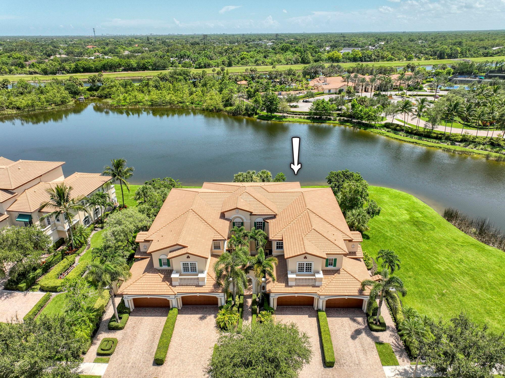 Breathtaking views could be yours from this exceptional single-story carriage home in the prestigious Jupiter Country Club. As a former model home, it boasts numerous luxurious upgrades and is set in an ultra-private location offering magnificent lake views. The thoughtfully designed one-level floor plan includes 2 bedrooms, 2 bathrooms, a den/office, and a 2-car garage, providing all the essentials for easy Florida living. Walking distance to the fitness club and pickleball courts, the home offers convenience and a vibrant community lifestyle. Furniture is negotiable, allowing you to tailor the space to your personal taste. Elegantly inviting, this energy-efficient residence features a tankless water heater, CBS construction, and impact glass windows throughout. Interior designer upgrades include Saturnia marble and hardwood flooring, crown molding, in-ceiling speakers, plantation shutters, and stylish light fixtures and ceiling fans. The gourmet kitchen is equipped with solid wood shaker cabinets with pull-out shelves, granite countertops, a large center island, built-in pantry cabinets, and an extended bar/cabinetry area. The open-concept living room offers stunning lake views, while the spacious primary suite includes a sitting area, a walk-in closet system, and additional custom-designed reach-in closets optimized for maximum storage. The luxurious primary bath features marble flooring, granite countertops, a frameless glass shower enclosure, and a deep soaking tub with elegant accents. The bright study/office is outfitted with a custom-built desk and storage area, complemented by hardwood floors. Enjoy sunsets and serene lake views from the screen-enclosed covered lanai, making this home a truly special retreat.