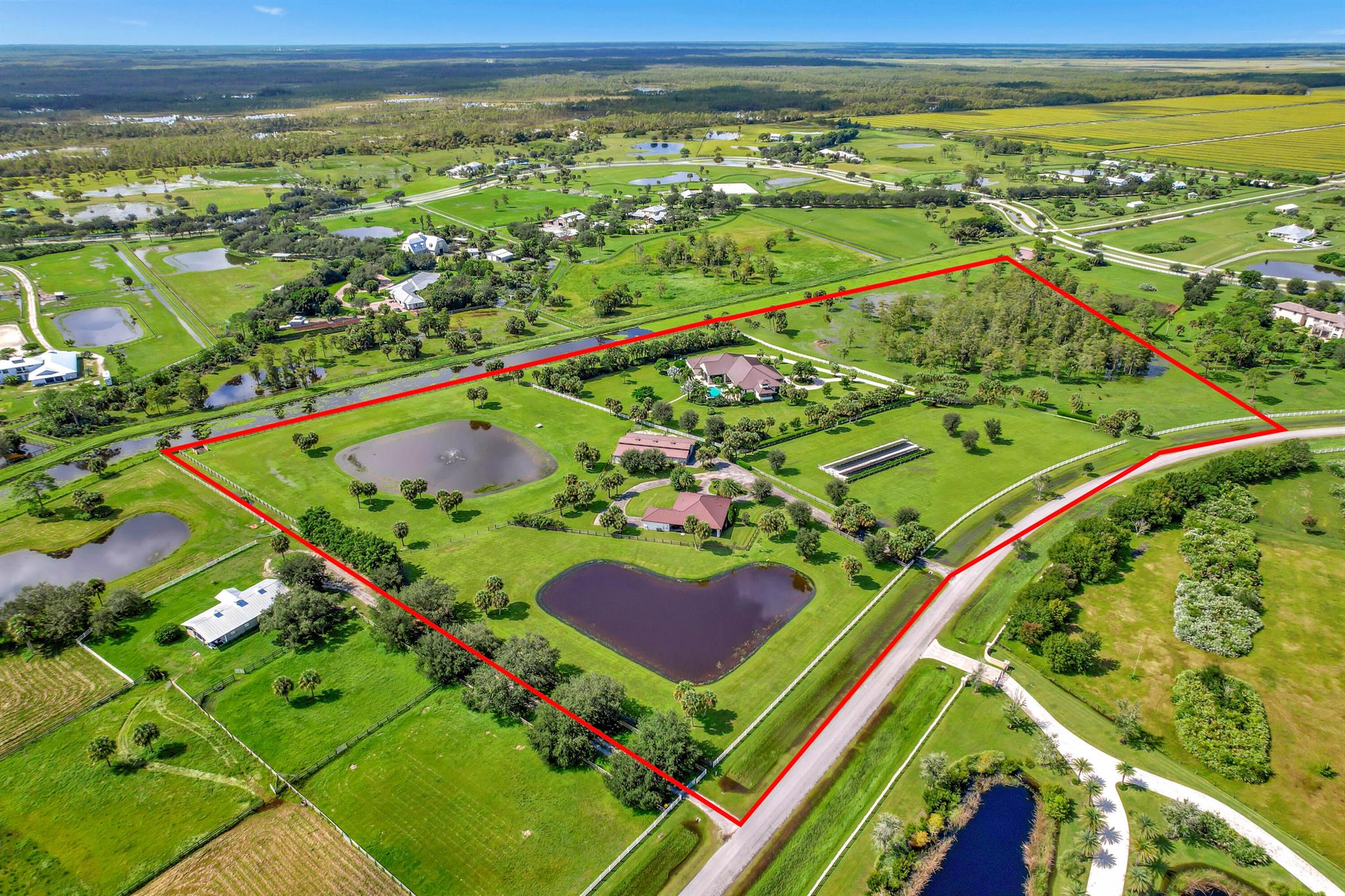 Welcome to the ultimate luxury retreat in Trailside, Hobe Sound--an exclusive gated community featuring just 41 sprawling estates. This stunning 2019-built, one-story custom home is a masterpiece, blending elegance, comfort, and off-the-grid sustainability. As the personal residence of one of South Florida's top custom home builders, no expense was spared in crafting this sanctuary. Boasting four spacious bedrooms, 4.2 lavish baths, and a four-car garage, this residence is designed for those who seek the finest in both style and function. The gourmet kitchen is a chef's dream, outfitted with Sub-Zero and Wolf appliances, exquisite quartzite countertops, and custom wood cabinetry that radiates sophistication. (See More) Every inch of this home is meticulously appointed with high-end finishes, motorized window treatments, custom lighting, impact windows and doors, and concrete block construction topped with a standing seam metal roof for unmatched durability and peace of mind.

Beyond its beauty, this property is a marvel of energy efficiency. A state-of-the-art solar farm and whole-house generator ensure uninterrupted, eco-friendly living. Outdoors, relax by the heated swimming pool and spa, all set against the backdrop of two serene private lakes.

And that's not all, this estate also features a nearly 2,000-square-foot guest house with two bedrooms, two baths, and a two-car garage. For equestrian enthusiasts, the fully-equipped barn includes an air-conditioned office, tack room, wash stall, equipment room, and modern horse stalls with private paddocks. The barn can easily be converted to an equipment barn for those not interested in horses.

This property's sustainable features are unmatched, from its top-of-the-line water filtration system to two wells, ensuring self-sufficiency. Whether you're looking for luxury, privacy, or a ranch that lets you live off the grid, this property offers it all.

Don't miss your chance to own a slice of paradise in Hobe Sound!