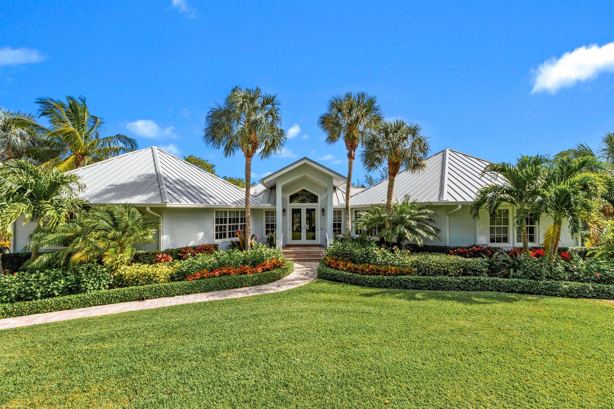 Gorgeous, light filled, 3B,2.5B turn key home on 1.5 acres of lush  tropical landscaped waterfront with ipe dock that has a lift, water & electric. 8 miles to Jupiter Inlet & 6 miles to Saint Lucie Inlet. Deeded ocean beach access just a short walk at the end of a private lane. Home features a new standing seam metal roof, impact windows & doors, wrap around ipe deck, renovated heated pool with new spa. Newly renovated primary bath, custom built in cabinets throughout, bar, new six burner stainless gas stove, stainless kitchen appliances and marble counter tops with open concept to spacious living area with center room gas fireplace. Minutes to town and airports. Very private and quiet.