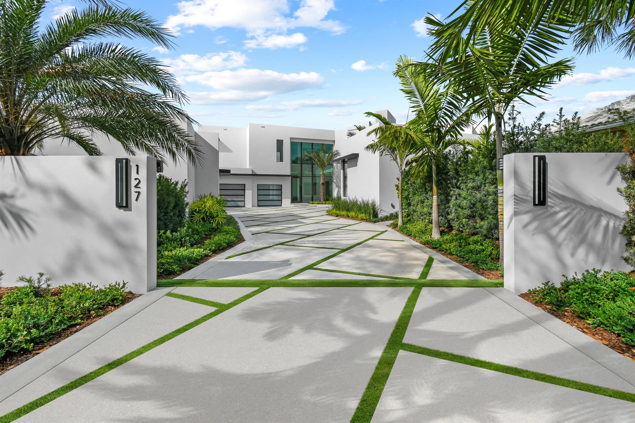 Welcome to a modern masterpiece in the prestigious Admirals Cove community in Jupiter. Nestled on a serene cul-de-sac, this newly constructed waterfront estate spans 13,115 square feet, offering panoramic views of the Intracoastal Waterway and golf course. The expansive lot features a private dock with unobstructed water access. The grand entrance opens to a spacious foyer with imported Italian large format porcelain tile flooring throughout. The first floor showcases a luxurious primary suite with a sitting area, lanai, and his-and-her closets. The gourmet kitchen is a chef's dream, complete with custom cabinetry made of rift cut oak and high gloss pearlized lacquer with solid core box construction, waterfall countertop, integrated dining area, rotating wine feature wall, Sub-Zero Wolf Cove appliances, and Galley kitchen sinks and faucets. Adjacent spaces include a club room with a stunning backlit Crystallo wall, a great room, and an office. Outdoor living is effortless with a lanai featuring a summer kitchen and breathtaking views. The second floor, accessible by an elegant staircase or elevator, features smooth European oak wood flooring, a queen master suite with a sitting area, private balcony, and spa-like bathroom. Three additional ensuite bedrooms provide ample accommodations, while a spacious gathering area and balcony offer more opportunities to enjoy the scenery. This 6-bedroom, 7-bathroom (plus 2 half baths) home includes a four-car garage, Savant home control system, Lutron motorized shades, tankless water heaters, and Electrolux laundry appliances. Finishes include Gessi custom bathroom fixtures, horizontal oak-grain stained doors, and Bernhardt custom furniture. Bespoke lighting enhances the entry staircase, kitchen, dining room, primary suite, and upstairs powder room. This waterfront sanctuary seamlessly marries modern luxury, unparalleled views, and the exclusive lifestyle offered by Admirals Cove. Don't miss the opportunity to call this waterfront retreat home.