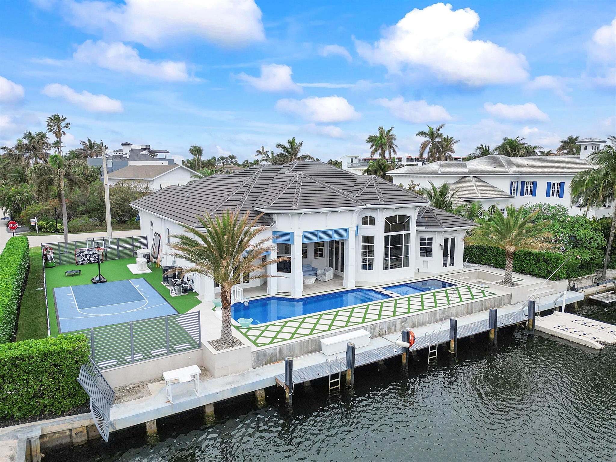 CUSTOM DESIGNER BEACH HOUSE! This unique, finely detailed and elegant home boasts entry doors made of Alder wood, white washed French oak floors, floor to ceiling carpentry and 500 gallon aquarium center piece. Italian tile & doors throughout with drapery, colors and crafted fixtures handpicked just for this home. High impact windows, roof 2019, 3 car garage, Meile appliances and NO EXPENSE SPARED w/ fully equipped control4 AUTOMATION SYSTEM including retracting patio screens. Master quarters include 12ft closet cabinetry, steam shower w/ built-in tv and stunning Italian handmade Swarovski crystal tiles. Home theater with fitted and imported Rolls Royce recliners. 100ft of water frontage w/ ocean access, in ground firepit, basketball court, SW heated pool w sun shelf & hot tub!