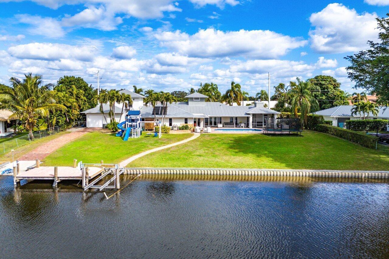 Sprawling waterfront property on the north end of Lake Ida with breath-taking sunset views down the length of the lake. This stunning Key West style single story home with metal roof sits on 2/3 of an acre with 150 feet of direct waterfront complete with boat dock and boat launch ramp. The home's spacious 3,765 sf includes 5 bedrooms, 5 1/2 bathrooms and a 3-car garage. Updated interior with tile flooring throughout, a quartzite waterfall kitchen island, induction cooktop and GE Monogram appliances. A full guest apartment with kitchenette is above the garage. A large yard and heated pool complete this incredible compound. Perfect for an active family who enjoys watersports, wave runners, fishing and fun. Close proximity to top private schools, Downtown Delray and the white sand beach.