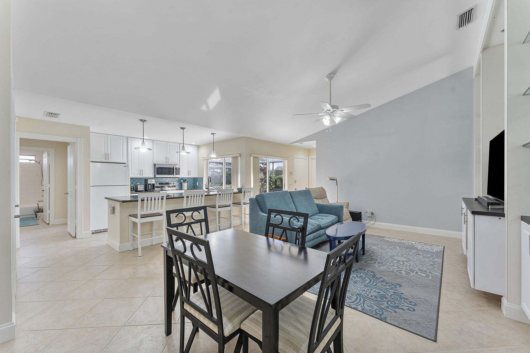Step into this beautifully designed 2-bedroom, 2-bathroom villa, where elegance meets comfort. The heart of the home is an open-concept living area bathed in natural light, boasting custom built-ins and a seamless flow into the modern kitchen. The kitchen features a sleek granite countertops, pristine white cabinetry, and a charming backsplash that adds a pop of color. The spacious primary suite is your personal retreat, complete with mirrored closets and direct access to the outdoors. The en-suite bathroom is tastefully updated with dual vanities, modern fixtures, and a walk-in shower designed for relaxation. A second bedroom offers versatility, perfect for guests or a home office, with its own private access to the serene patio. Speaking of outdoor living, the expansive screened patio is a true gem. Imagine hosting gatherings, enjoying your morning coffee, or simply soaking in the Florida sunshine in this tranquil space surrounded by lush greenery. Practicality meets convenience with an in-unit laundry area and ample storage options, including a bonus utility room.