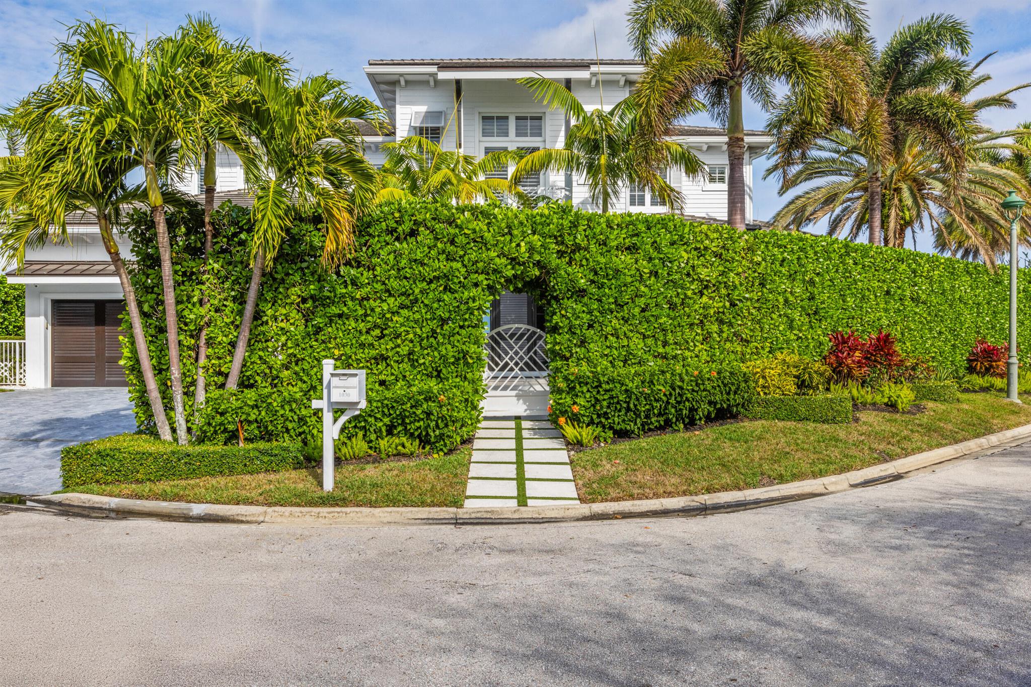 Welcome to 1030 Pine Point, a stunning West Indies-inspired waterfront estate with breathtaking water views offering timeless elegance and modern sophistication. Built in 2017, this exceptional home boasts 150 feet of direct Intracoastal frontage with a 125-foot dock featuring dual boat lifts, making it a boater's dream. Perfectly situated just minutes from the inlet and the pristine beaches of Singer Island, this property offers a lifestyle of unmatched coastal luxury. Spanning nearly 6,500 total square feet, the residence features 5 bedrooms, 6.5 bathrooms, and exquisite craftsmanship throughout. Highlights include European oak wide-plank flooring, a striking Calacatta Maple kitchen island, and a chef's kitchen equipped with top-tier Thermador appliances. Natural stone finishes adorn every bathroom, while refined details like tongue and groove boxed ceilings, wainscoting, and solid 8-foot doors showcase sophisticated design. Outdoor living is just as impressive, with a 40-foot wide patio, a heated saltwater pool and jacuzzi, a summer kitchen, and a gas fire pit, all surrounded by lush landscaping and illuminated by custom lighting. Engineered for durability and convenience, the home includes impact sliders, a whole-house generator, and a state-of-the-art water filtration system. Find marine life appearances featuring Sea Turtles, Manatees and Snook. Walk to the beach and beautiful Ocean Reef Park. Less than 10 minutes to renowned shopping and dining on PGA Blvd and just 20 minutes to Palm Beach and the PBI airport. Discover a waterfront gem that seamlessly blends luxury, style, convenience and functionality.