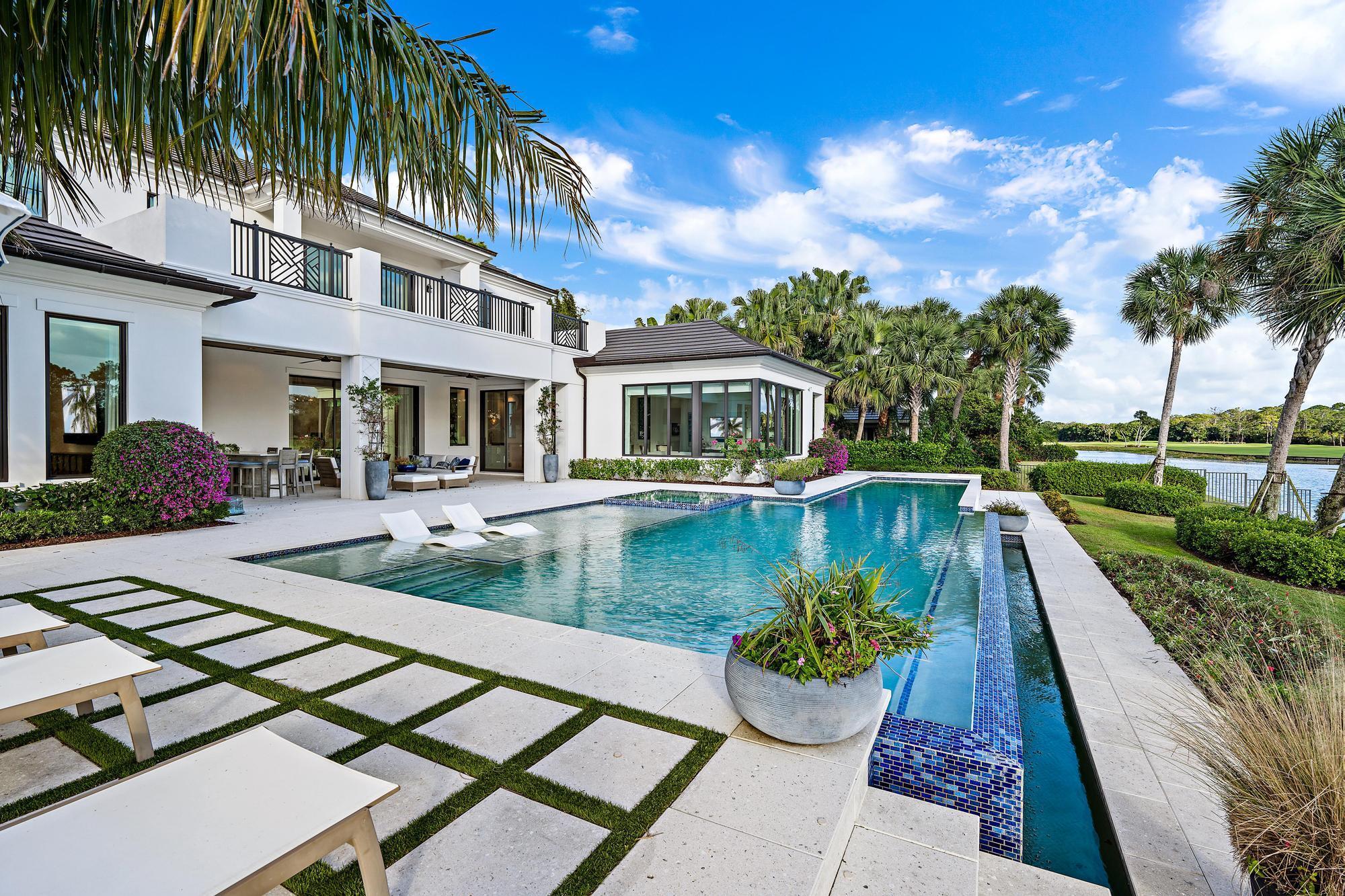 Nestled within the gated golf community of Old Marsh Golf Club, this 2019 custom built estate boasts expansive water, golf and preserve views.  The architectural detail paired with the interior design appointments captures a stately yet welcoming residence.  Mature oaks framing the entry drive to a motor court surrounded by garages for 4+ cars, one complete with a lift for the auto enthusiast and ceiling heights allowing for additional lifts.  A beautiful front elevation with white brick detail, copper gutters and stunning, painted mahogany entry doors, welcomes you to one of the finest settings in Palm Beach Country.  The foyer with oak flooring laid in a herring bone pattern leads to a formal living area with fireplace, sliding glass doors opening to a spacious outdoor living area..more and summer kitchen, electronic screens opening to a breathing infinity edge swimming pool (with lap area) overlooking the lake and the 7th and 8th holes of the Pete Dye Championship design golf course.  Chef's kitchen, bar, amazing pantry, family room with unmatched views, media room, spectacular primary suite and seperate guest suite are all located on the main level while the upstairs is highlighted by a dedicated fitness room with sliders to a spacious balcony, two guest suites and a casual living area for children or guests.  Generator, hurricane impact windows and doors - no detail has been overlooked.  Old Marsh is a low density gated enclave with 180 homes and a golf membership limited to 275.  A renowned caddie program, no tee-times and an award-winning club create an opportunity that is not to be overlooked.  Welcome home to a luxury lifestyle located only minutes to Palm Beach International airport, 5-star dining, beautiful south Florida beaches and endless shopping from the Gardens Mall to Palm Beach.