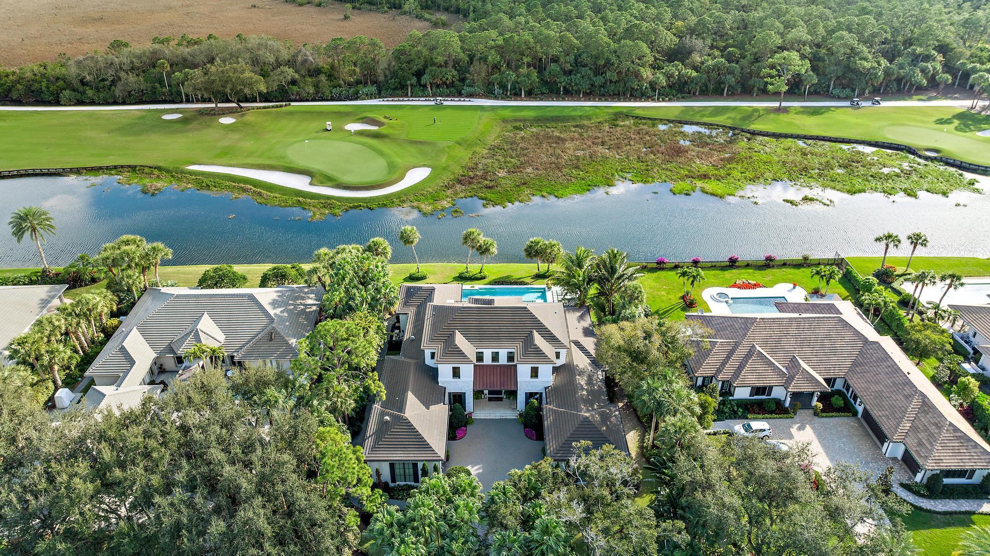 Nestled within the gated golf community of Old Marsh Golf Club, this 2019 custom built estate boasts expansive water, golf and preserve views.  The architectural detail paired with the interior design appointments captures a stately yet welcoming residence.  Mature oaks framing the entry drive to a motor court surrounded by garages for 4+ cars, one complete with a lift for the auto enthusiast and ceiling heights allowing for additional lifts.  A beautiful front elevation with white brick detail, copper gutters and stunning, painted mahogany entry doors, welcomes you to one of the finest settings in Palm Beach Country.  The foyer with oak flooring laid in a herring bone pattern leads to a formal living area with fireplace, sliding glass doors opening to a spacious outdoor living area..more and summer kitchen, electronic screens opening to a breathing infinity edge swimming pool (with lap area) overlooking the lake and the 7th and 8th holes of the Pete Dye Championship design golf course.  Chef's kitchen, bar, amazing pantry, family room with unmatched views, media room, spectacular primary suite and seperate guest suite are all located on the main level while the upstairs is highlighted by a dedicated fitness room with sliders to a spacious balcony, two guest suites and a casual living area for children or guests.  Generator, hurricane impact windows and doors - no detail has been overlooked.  Old Marsh is a low density gated enclave with 180 homes and a golf membership limited to 275.  A renowned caddie program, no tee-times and an award-winning club create an opportunity that is not to be overlooked.  Welcome home to a luxury lifestyle located only minutes to Palm Beach International airport, 5-star dining, beautiful south Florida beaches and endless shopping from the Gardens Mall to Palm Beach.