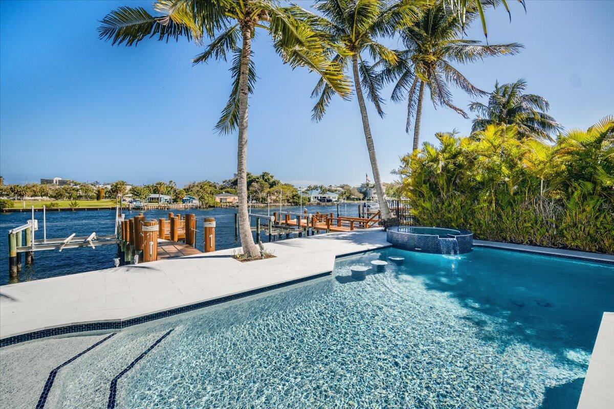 You will love everything about this property! This direct intracoastal home completely reimagined in 2024 is ready for you this season. Located in a boutique gated community, this is a boater's dream complete with private dock, 20,000 lb lift and direct ocean access with no fixed bridges, just minutes to the Palm Beach inlet. Elevated palm beach chic design paired with Downsview custom kitchen, top-tier Wolf and Sub-Zero appliances, including an integrated Wolf espresso machine. Wake up to sunrises over the water & unwind in your spa-like bath with a freestanding Roman tub, large walk-in shower, and Toto Washlet. Designed for seamless outdoor-indoor living with massive sliders opening to your outdoor retreat with marble hardscape, refinished saltwater pool with a new heater,