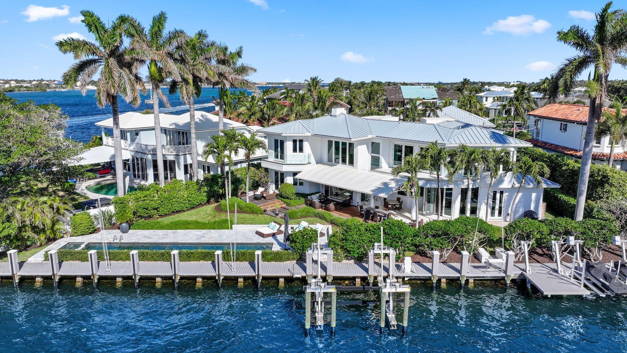 This outstanding 5 Bedroom 3.5 Bath contemporary waterfront sanctuary perfectly blends modern luxury with the ultimate Florida lifestyle. Boasting 166 feet of protected deep water dockage with wide Intracoastal views, it is just seconds to the Boynton Beach Inlet.Step inside through a custom mahogany door and be immediately captivated by breathtaking Intracoastal views. The spacious living room features soaring volume ceilings and a stunning gas/wood-burning fireplace, creating a warm and inviting atmosphere. Designed with impeccable attention to detail, this home seamlessly blends elegance and functionality. The chef's kitchen is a culinary dream, equipped with top-of-the-line appliances, including a Sub-Zero refrigerator/freezer and a Miele 8-burner gas range with double ovens. A walk-in pantry with an additional refrigerator and a climate-controlled wine room complete this entertainer's paradise. Adjacent to the kitchen, the casual family room offers unobstructed water views, making it the perfect spot to relax or host guests.

This home features five luxurious bedrooms, including a show stopping primary suite upstairs. The primary suite boasts two custom walk-in closets, a spa-inspired bath with a soaking tub, and a wraparound balcony with panoramic Intracoastal views. Two additional upstairs bedrooms each feature private balconies, while two main-level guest suites provide privacy and comfort for visitors.
The outdoor spaces are truly exceptional. A 50-foot heated saltwater pool anchors the backyard, surrounded by multiple seating areas ideal for entertaining. For boaters, the property offers a 60,000-pound boat lift, jet ski lifts, an electric paddleboard/kayak lift, and a full-service dock with water and electric connections. With its close proximity to the Boynton Beach Inlet, ocean access is just minutes away.

Additional features include all-new impact windows and doors, a 2-year-old roof, a central vacuum system, a Sonos speaker system, and three zones of AC for optimal comfort.
As a resident of McCormick Mile, you'll enjoy exclusive access to a private oceanfront beach club with stunning Atlantic views. Conveniently located near Palm Beach International Airport, Worth Avenue, and The Royal Poinciana Plaza, this home offers the perfect blend of luxury and lifestyle.

Key Features:

Grand Entrance: Custom mahogany door, soaring ceilings, and gas/wood-burning fireplace with stunning Intracoastal views.

Chef's Kitchen: Sub-Zero refrigerator/freezer, Miele 8-burner gas range with double ovens, walk-in pantry with refrigerator, and climate-controlled wine room.

Bedrooms: Five total, including a primary suite with wraparound balcony and spa-like bath, two upstairs bedrooms with private balconies, and two main-level guest suites.

Outdoor Living: 50-foot heated saltwater pool and multiple seating areas for entertaining.

Boating Amenities: 60,000-pound boat lift, jet ski lifts, electric paddleboard/kayak lift, full-service dock with water and electric connections.

Upgrades: All-new impact windows and doors, 2-year-old roof, central vacuum, Sonos speaker system, and three AC zones.

Beach Club Access: Exclusive membership to McCormick Mile's private oceanfront beach club with parking and breathtaking views.


Prime Location: Minutes to the Boynton Beach Inlet, close to Palm Beach International Airport, Worth Avenue, and The Royal Poinciana Plaza.