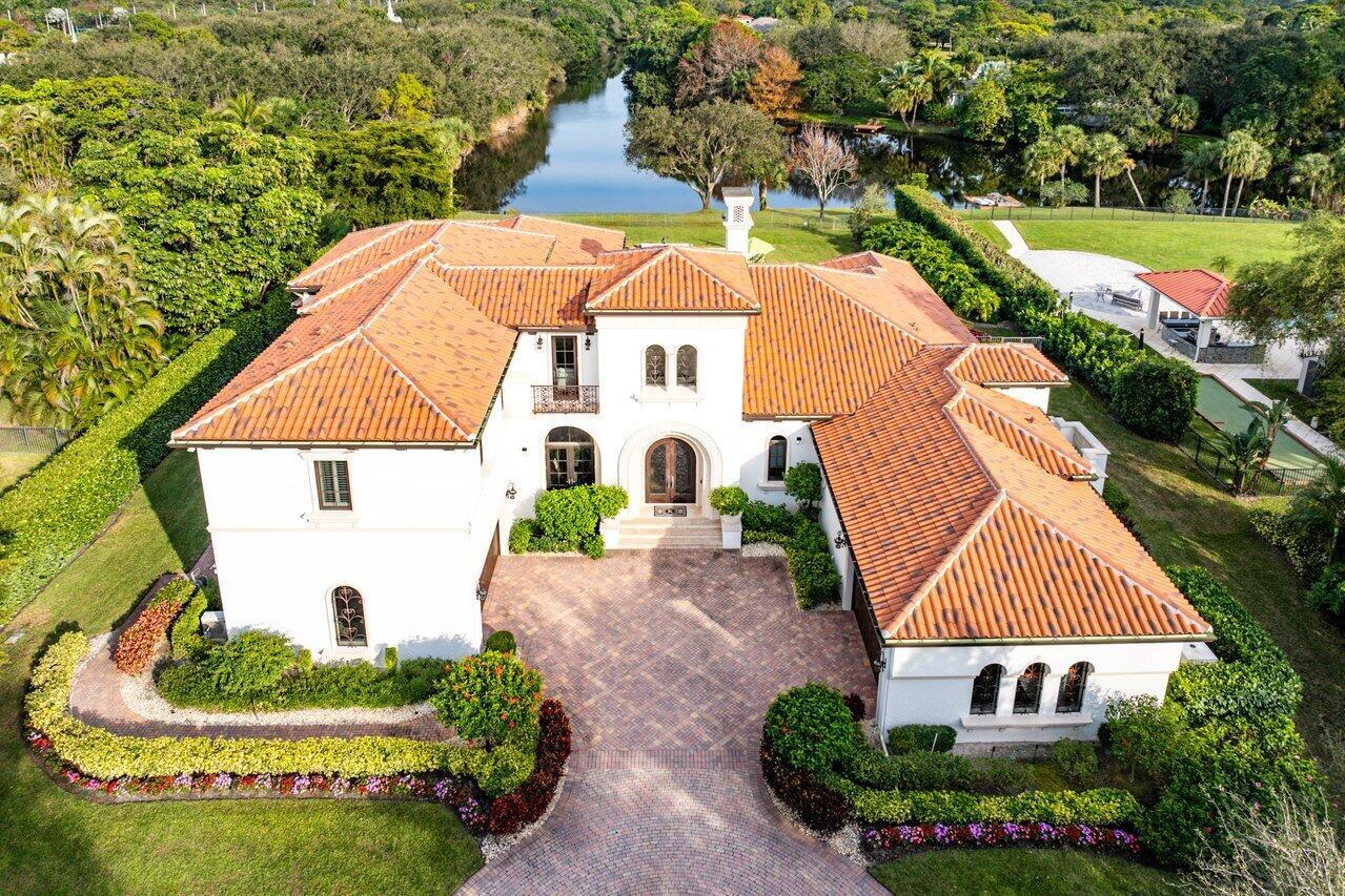 Discover unparalleled luxury and breathtaking water views from this exquisite 7,200 sq. ft. Sabatello Signature estate located on an acre in the prestigious Steeplechase community. Tucked away on a quiet cul-de-sac, this meticulously designed residence offers 5 bedrooms, 6.5 baths, an elegant library/office, a spacious media/bonus room, a second-story loft with sitting and study areas, and a four-car garage to enjoy. From the grand entry with intricate ironwork to the custom millwork throughout, every detail exudes quality and sophistication. The primary suite is a private retreat featuring a sitting area highlighted by large arched windows displaying pool and lake views, exercise/hobby space with a juice bar, 2 spacious walk-in closets with built-in organizers, and 2 luxurious spa- like bathrooms.

The gourmet kitchen is a chef's dream, boasting rich wood cabinetry, granite countertops, expansive center island and top-of-the-line appliances including Sub-Zero, Thermador, Bosch, and Dacor. Entertain effortlessly in the expansive covered loggia with a summer kitchen, gas BBQ, and Sub-Zero fridge, all overlooking the stunning pool, spa, and cascading water features.
 
With lush landscaping, a circular brick-paved driveway with a tiered fountain, and stunning wide water views, this estate offers the perfect blend of elegance, privacy, and convenience. Four-zone A/C and modern automation systems complete this exceptional property. A true masterpiece in one of Palm Beach Gardens' most sought-after communities!