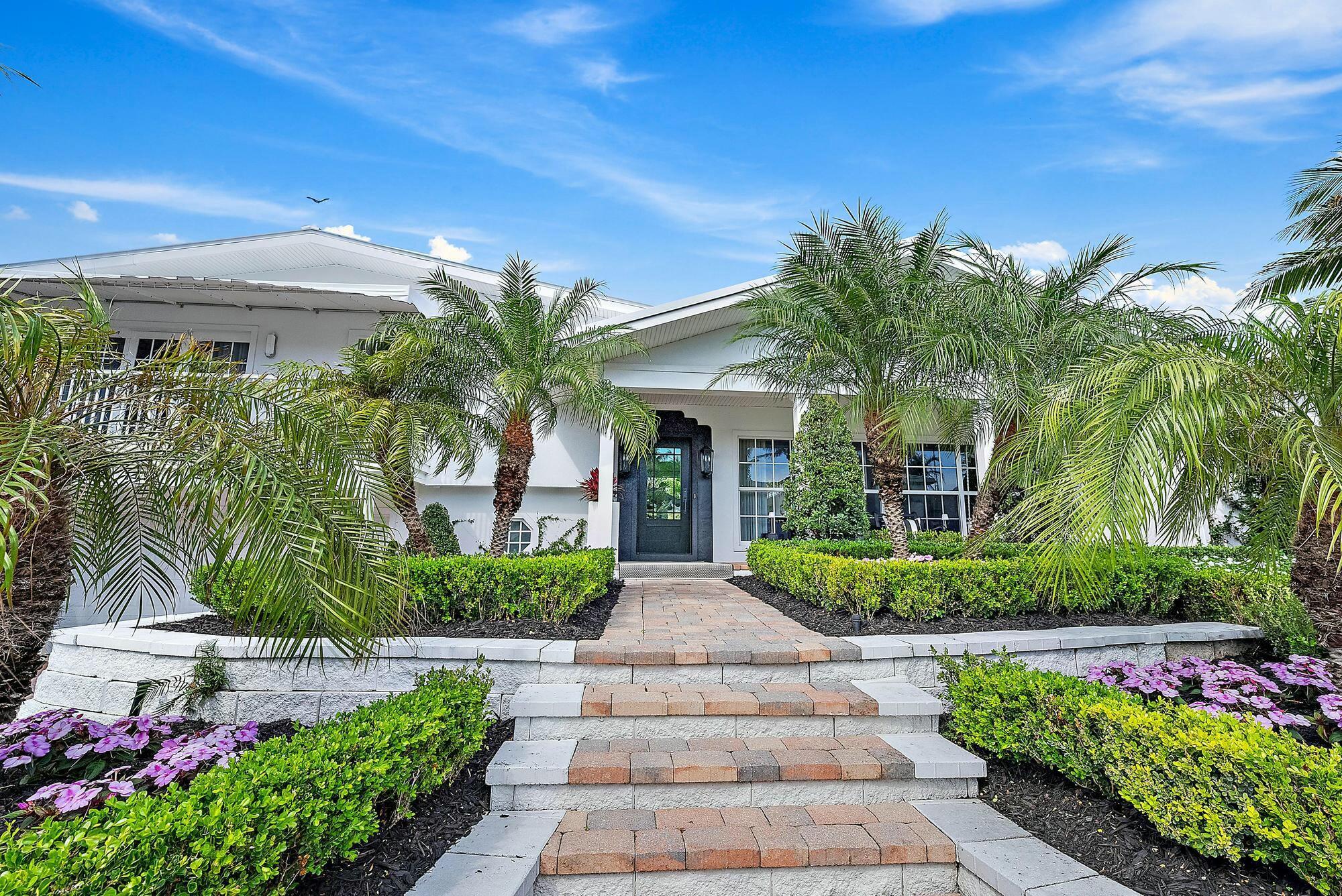 AMAZING LOCATION! This sophisticated 4-bedroom, 4-bathroom home, fully renovated in 2024, is situated in the prestigious Town of Jupiter Inlet Colony, at the most southern tip of highly desirable Jupiter Island. Positioned right in the heart of town, just a short distance from both beach paths, this home offers the ultimate in convenience and coastal charm.Framed by lush tropical landscaping and beautifully complemented by Palm Beach-style espalier trellis walls, this residence sits on a highly elevated 10,450 Sq. Ft. private lot, ensuring privacy and tranquility with no homes directly behind the backyard. The home highlights "Coastal Living" accentuating the relaxed yet sophisticated open-concept, vaulted ceilings and exposed beams. Natural light flows-in from both sides and it is entirely fitted with impact rated windows and doors. Enjoy the delightful breezes