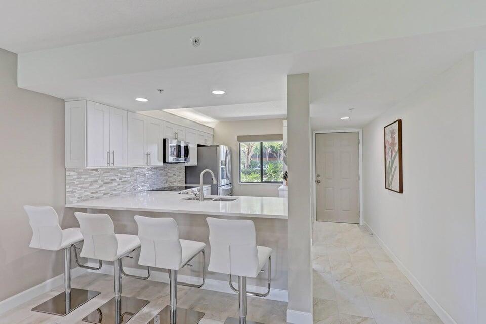 Are you looking for a ground floor condo with a water view that is updated to the max? Completely move-in ready with impact windows and doors, LED lighting, porcelain tile flooring through out, stainless steel appliances, and quartzite counters. 2/2 with separate laundry room with bonus area that can be used as for storage, an office, or small gym. ROOF 2022. Marina at the Bluffs offers beautiful landscaping, sidewalks, 4 salt water pools, two tennis courts, and one bocce ball court. Extremely close to the beach, shopping and dining. The building recently passed the 40 year certification. Built by Berg & DiVosta Development Company, best known for its energy-efficient building practices. No other ground floor units on the market that our completely updated. Don't wait!