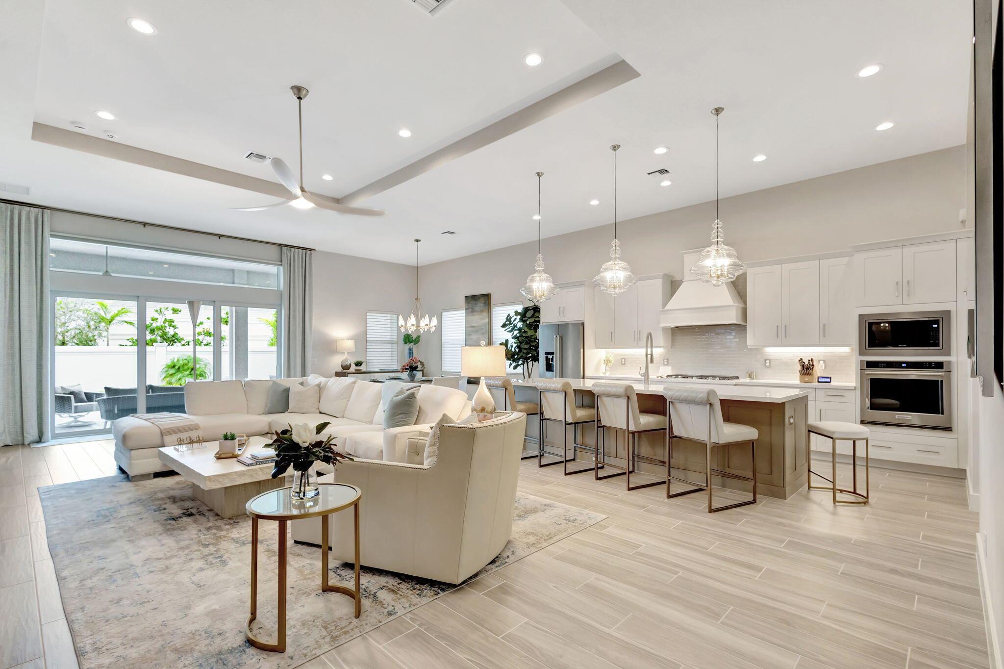 This Stylish home greets you with a covered porch and a welcoming entry, leading into a grand foyer that opens to an expansive great room. The center piece of this home is a stunning Chic custom 25' wall unit with glass shelves, rich cabinetry, quartz countertops, beverage refrigerator, floor to ceiling decorate tile work, electric 75'' modern flames fireplace and 85'' TV with Sonos sound bar. The bright and airy casual dining area flows seamlessly into a spacious covered lanai, perfect for relaxing or entertaining. The well-appointed kitchen boasts a large center island with a breakfast bar, generous counter and cabinet space, and a roomy walk-in custom pantry. The elegant primary suite features a coffered ceiling, dual custom walk-in closets, and a luxurious en-suite bath with a dual sink vanity, soaking tub, large glass-enclosed shower, linen storage, and a private water closet. The secondary bedroom offers  a custom closet and shares a bathroom with separate dual-sink vanities with the 3rd bedroom with walk- in custom closet. Additional highlights include a private flex room off the foyer, a convenient powder room, a centrally located laundry room, and plenty of extra storage space. Step outside into the private oasis offering a spacious yard and luxurious pool.  Upgrades include, custom designer lighting and fans throughout, custom closets, custom window treatments, custom built-in wall unit, beverage refrigerator, 75" fireplace, 85" TV, Sonos sound bar, California closet custom pantry, whole house generator, outdoor kitchen, built in double kegerator, beverage refrigerator, sink, built-in gas grill, granite wall, granite countertops, dual phantom electric privacy and noseeum screens, 75" TV, wi-fi access port in Lani and much more. This luxury home offers sophisticated, single-level living featuring modern, open-concept floor plans perfect for entertaining. Experience private, resort-style living at its finest in this vibrant Regency Avenir community.  Located in the sought-after Palm Beach Gardens, this community blends contemporary home designs with exceptional amenities, all set in a relaxed and inviting atmosphere. Residents of Regency at Avenir in sought after Palm Beach Gardens enjoy exclusive access to The Pearl, the community's 22,000 sqft private clubhouse offering an onsite activities director, a wide array of special interest clubs, activities, and events. Amenities at The Pearl include a picturesque resort-style pool, spa, pickleball, tennis, two fitness centers, wine storage, card and game rooms, ball room, indoor/outdoor lounge, a golf simulator, outdoor amphitheater, outdoor game area and much more. Conveniently located near Sand Hill Crane Golf Club an 18-hole championship course, The new Nest Par 3 Course and various dining options. Across the street is PGA National's Estate Course, with membership options available. Minutes away from shopping, dining, the Airport, Palm Beach and so much more.