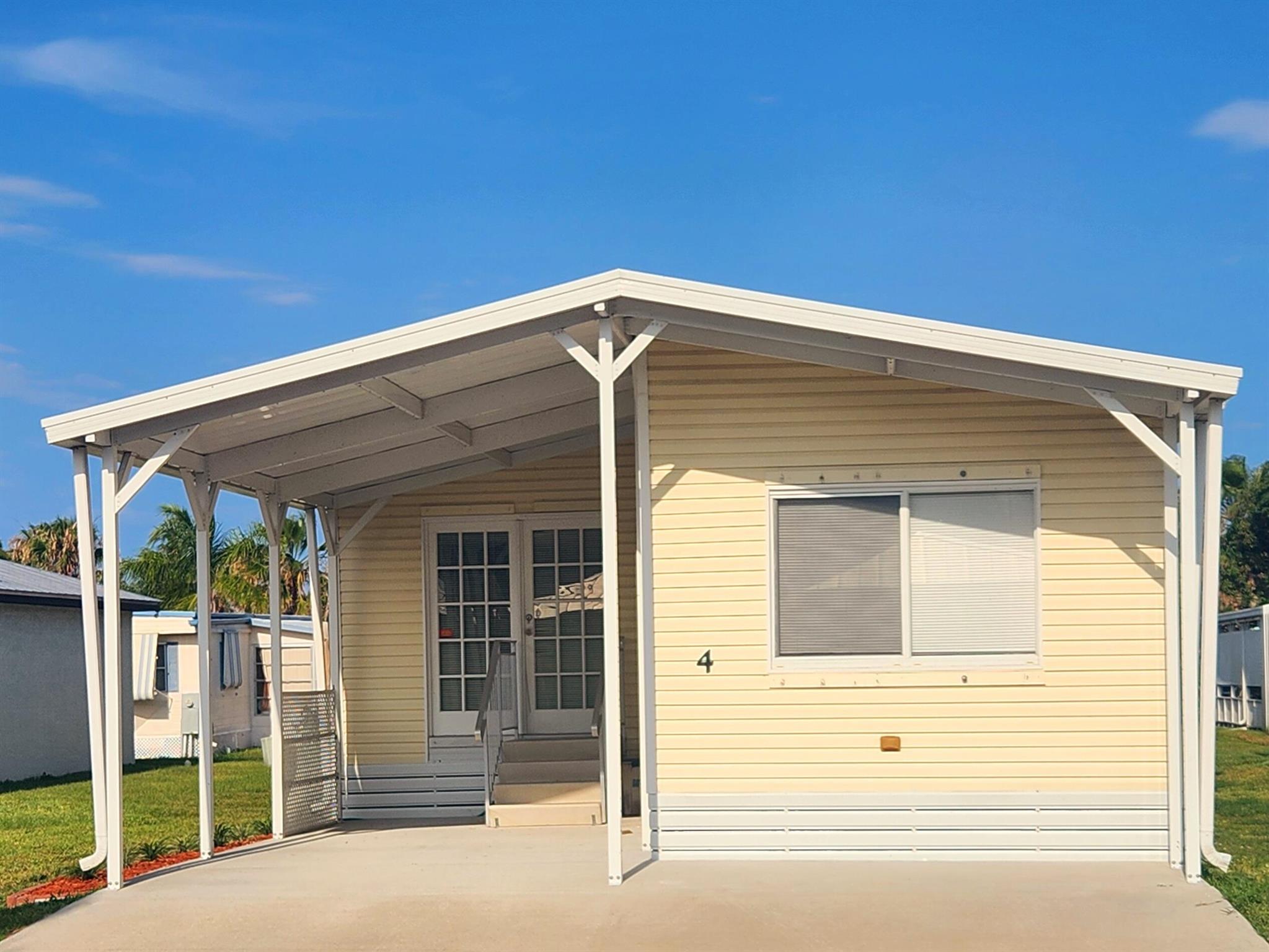 Charming 2bed,2bath nestled in a quiet 55+ community. New carpet & sliding glass doors & a 2018 Roof! This home boasts a beautiful, bright, spacious floor plan w/ a UNIQUE deck perfect to enjoy outdoors, whether it be morning coffee or evening star gazing. Comes w/ complete set of storm shutters! Clean,solid, & well kept, turn key home located minutes from beach, offers the best of coastal living & convenience; 1-2 miles from grocery, bank, pharmacy, post office & more. Tranquility or a beachside getaway, this home has it all. Land lease $733.91 includes lawn care, trash pick up, private golf course (no fees to play) heated pool, fitness, pickleball, tennis, shuffleboard, bocce, gym, library, cards, Mah Jong, bible study, workshop, golf cart parades, dinners, dances, security,  & more!