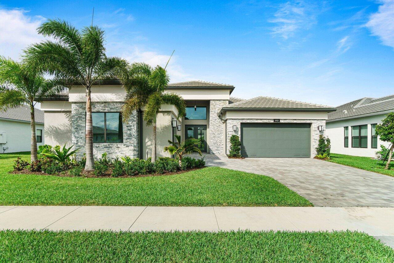 Stunning 4 BD 4 BA home on the lake in the prestigious Valencia Grand of Boynton Beach. Built in 2023, the Carmel model home exudes modern elegance and upscale living. Large sliding doors flood the space with natural light, seamlessly connecting the indoors to the scenic patio. Light tile floors and sleek white finishes in the kitchen enhance the airy, open feel of the home. A versatile open space adjacent to the main hallway offers endless possibilities; whether as a den, office, dining area, or family room, it can be customized to fit your needs. The primary suite is a retreat, featuring serene lake views, a luxurious ensuite bathroom, and two spacious walk-in closets. Three additional bedrooms provide ample space, two of which are ensuite for added privacy.