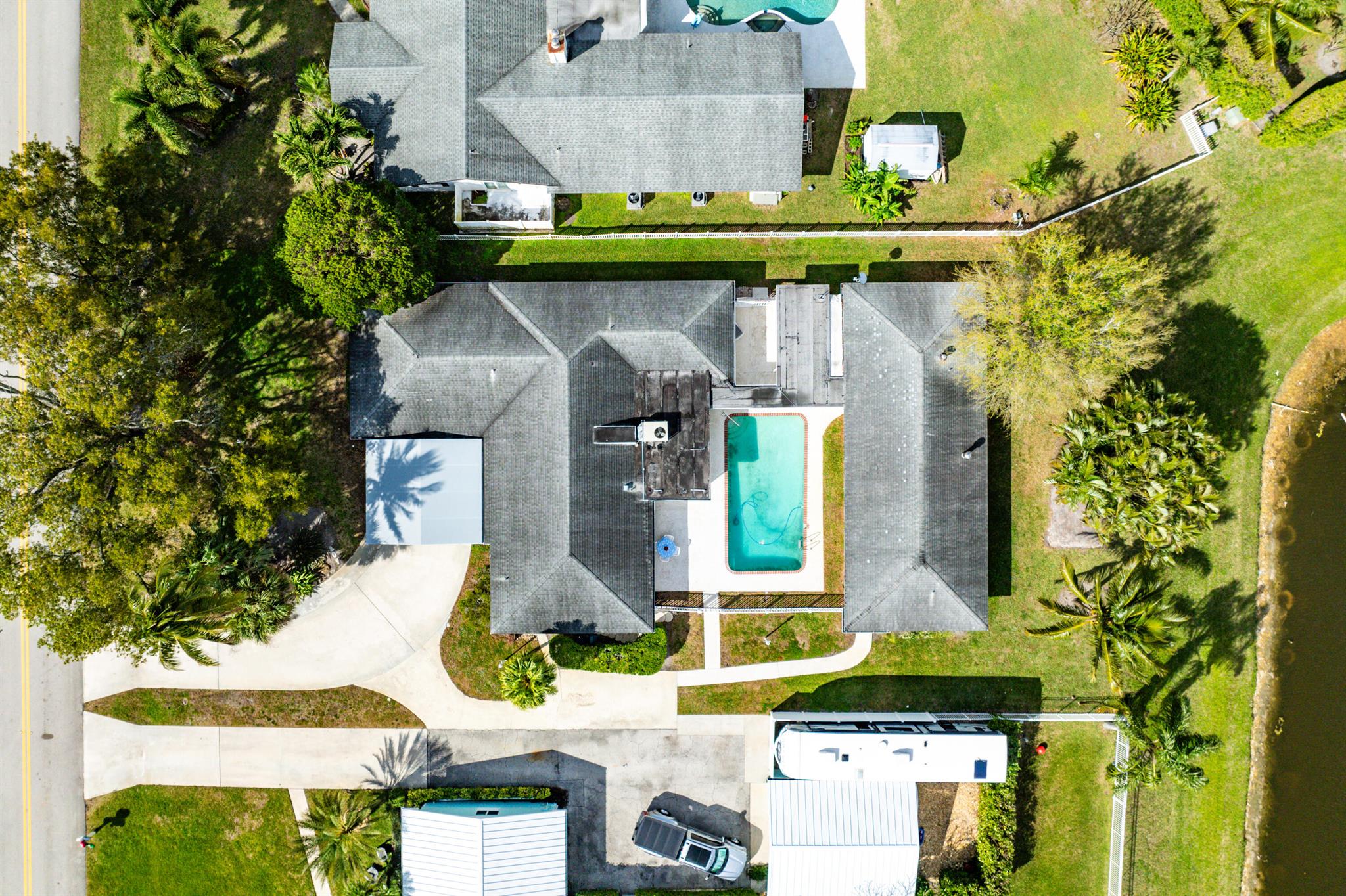 This former model home, located in the heart of Palm Beach Gardens, features 2 homes well maintained by its original owner. Situated on a quiet street, with no HOA and no through traffic. The main home offers 4 bedrooms 2.5 baths, including a large game room and Florida room. The second home separated by a  courtyard and over-sized pool, offers 1 bedroom 1.5 baths, with a full kitchen, laundry area, private entrance and backyard. Abundant space for large RV and boat storage. Don't miss out on this one of a kind family compound.