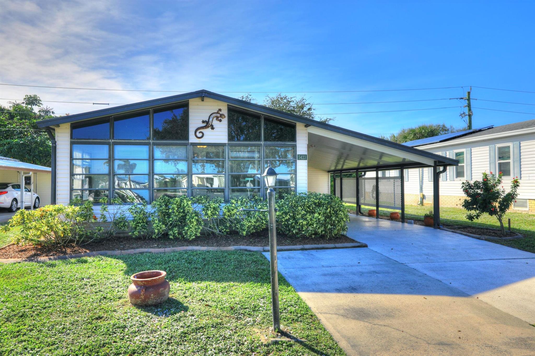 Home has Metal Roof and Newer A/C. The spacious interior seamlessly flows from the dining room with its elegant built-in cabinet to the inviting living room that extends out to a charming, raised glass-enclosed porch. The kitchen boasts a practical rolling bar, perfect for entertaining guests. Additionally, a large workshop complete with ample built-in storage awaits, offering endless possibilities for creativity and organization. Bonus: home comes fully furnished.