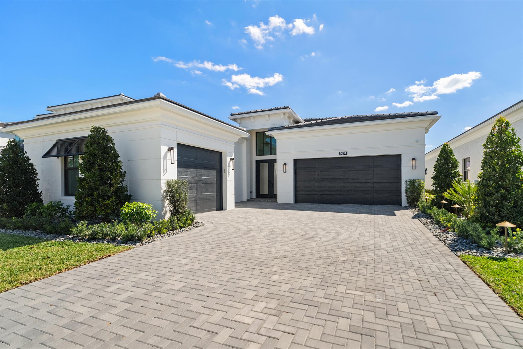 This stunning home is the largest single-story model in Artistry and is situated on a premium homesite with southern exposure and direct lake & fountain views! This impeccable home was just built and enhanced with over $500,000 of luxurious features! This 3 bedroom 3.1 bathroom home was designed to unwind and entertain. The swanky clubroom adds to the expansive space, and can also be a 4th bedroom. The gourmet kitchen features elevated cabinets, Monogram appliances with gas cooktop, 48'' refrigerator, quartz countertops & island with waterfall, and a dry bar complete w/ a wine cooler & ice maker. The primary bedroom & bathroom are a serene retreat with stylish lighting fixtures, a soaking tub, frameless shower, and a Toto bidet toilet. All closets are custom built by California Closets. Enjoy your backyard and summer kitchen in any weather with a large covered lanai and motorized phantom screen.  Relax in the saltwater heated pool with beautiful water features. The home has two air-conditioned garages to fit 3 cars, and one is outfitted with an outlet to charge your EV vehicle. Some additional features that are sure to impress are: motorized Hunter Douglas window treatments throughout, a whole house generator, custom stone walls with built-ins, crown molding, and LED chips in all lighting fixtures so you never have to change a bulb! The home is fully automated with smart locks, a video doorbell, alarm and smart thermostat. Artistry residents have a gated entrance and exclusive access to a beautiful clubhouse with fitness center, resort-style pool, basketball courts, and more. Benefit from A-rated schools and proximity to pristine beaches, upscale shopping, exquisite dining, and golf courses. This home has it all. Don't miss the opportunity to make this home yours.