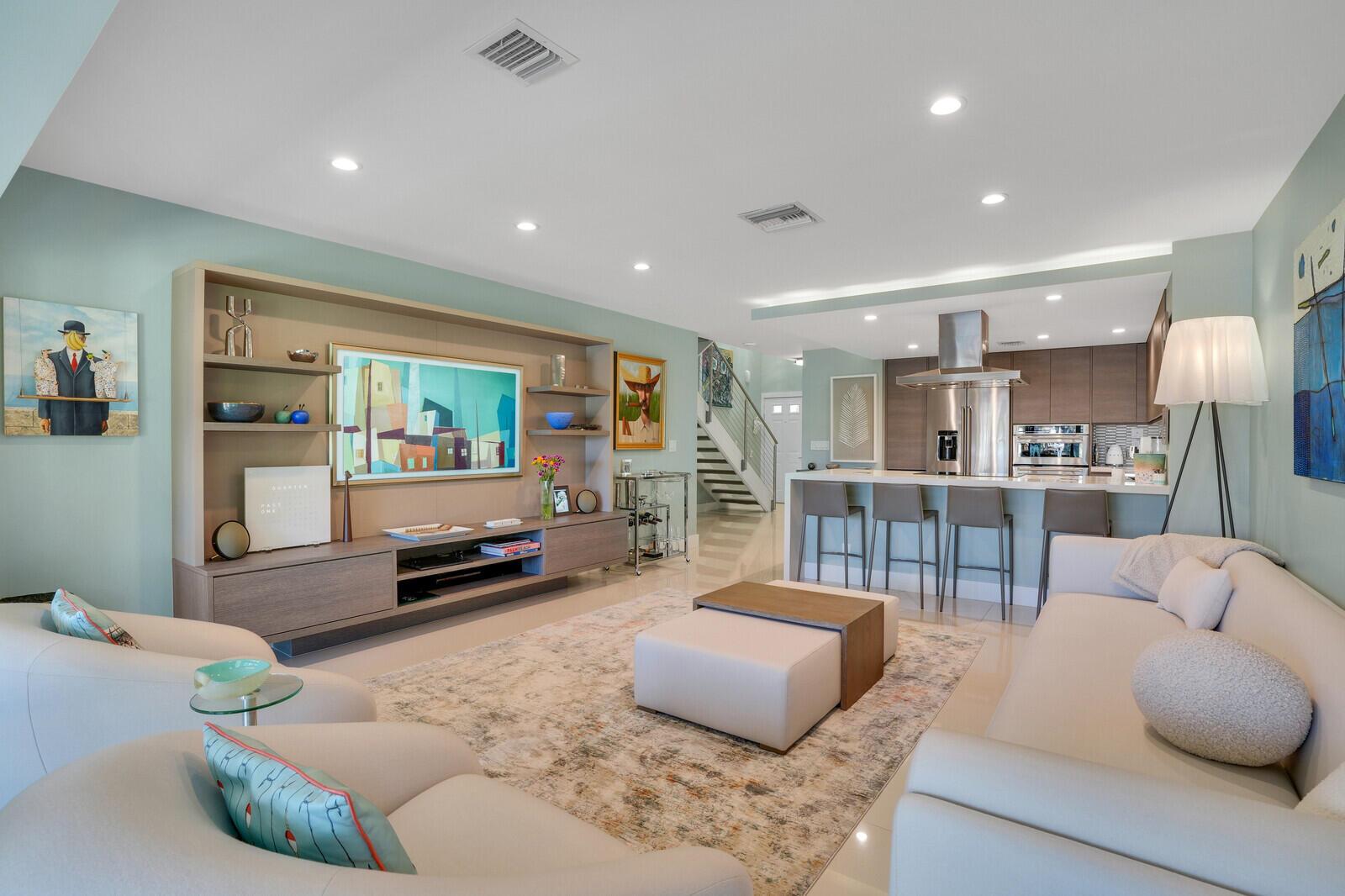 Stunning, Contemporary End unit Townhome w/ boat slip. Embrace the ultimate Palm Beach lifestyle in this one-of-a-kind townhome, featuring a direct line of sight to your own deeded boat slip on the intracoastal. Step into your personal sanctuary, where modern design harmonizes with comfort.  Four minutes away from fabulous beaches, upscale shopping, and exquisite dining, this airy home offers an unparalleled cosmopolitan experience, ideal for professionals and urban enthusiasts alike. Relax in your beautifully landscaped backyard oasis, surrounded by palm trees--a tranquil retreat after a long day. Enjoy convenient access to a new gym/clubhouse, and a swimming pool, providing the perfect blend of healthy living and urban convenience.   This impeccable home showcases an array of contemporary design features, including polished porcelain floors throughout, custom millwork, and kitchen cabinets. The gourmet kitchen is equipped with high-end Bosch and KitchenAid stainless steel appliances.   An open-concept staircase with stainless steel railings leads to two spacious bedrooms, each featuring ample linen and closet space, along with ensuite bathrooms. On the main floor, a versatile office appointed with custom cabinetry and bathroom serve as a modern workspace and doubles as an additional bedroom for overnight guests. Additional luxury features include a wireless state-of-the-art LG washer and dryer, a tankless hot water system, and a heated towel rack in the master bedroom. The home is equipped with dimmable LED lighting throughout, a newly installed Honeywell alarm system, a Nest doorbell, and two Nest cameras monitoring the covered parking stall and boat slip. Solid core doors (for acoustic privacy) and remote-controlled privacy blinds further enhance the elegance and convenience of this property. Move-in-ready.    Don't miss this exceptional opportunity!