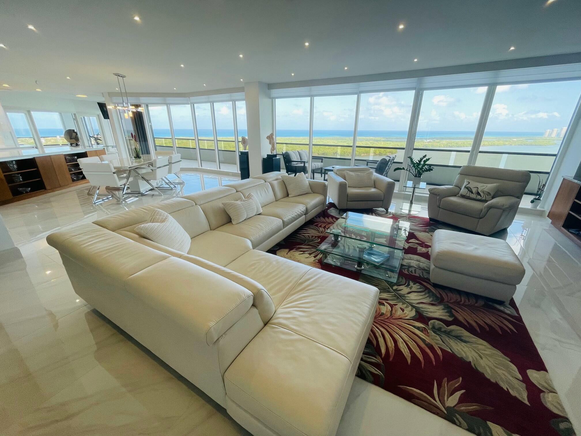 Stunning Luxury Residence Once in a lifetime opportunity to own a breathtaking, architecturally designed and completely reimagined residence in the prestigious 100 Lakeshore Tower. This exquisite 3-bedroom, 3.5-bathroom 18th floor high rise condominium home offers an unparalleled combination of elegance, and modern sophistication.Step inside to discover porcelain flooring throughout, setting the stage for a sleek and timeless aesthetic. The gourmet kitchen is a chef's dream, featuring top-of-the-line Thermador appliances, granite and onyx countertops, and custom cabinetry perfect for culinary enthusiasts and entertainers alike.Designed to maximize comfort and style, the fully open-concept living and design. Don't miss your chance to experience the ultimate waterfront lifestyle. 18th Floor Unit with ceiling glass provides incredible Views of the  Atlantic Ocean Inland Waterway Lagoon and Harbor. Features Include: New Thermador Refrigerator, Electric Stovetop, Oven, Microwave, Dishwasher, Wine Cooler, Electrolux Washer and Dryer. New LED Lighting Fixtures throughout. Two New 75" Samsung wall-mount TVs Plus 47" and 45" wall-mounted TVs. New Aluminum Hurricane Shutters. Fully Motorized Hunter Douglas Window Blinds throughout. Air Conditioned Garage Storage Unit and Two Garage Parking Spots. This Castle in the sky is truly one of a kind.