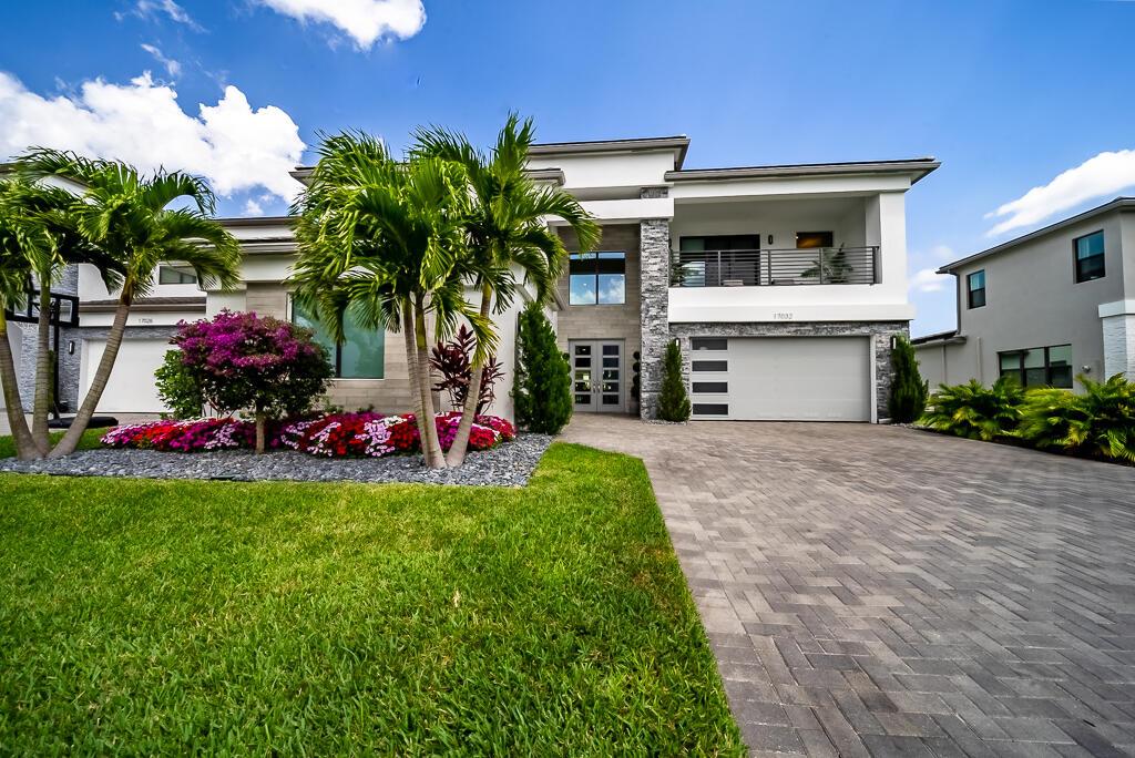 Discover your lakeside dream home in the prestigious Lotus community of Boca Raton. This Sumatra model features 6 bedrooms, 6.5 bathrooms, an office, a loft, a spacious 3-car garage, and a sprawling 4,926 sq ft of luxury living. Not only does it offer wide open lake views and a stunning pool, but it truly shows like a model home! Step inside to find a welcoming foyer with a beautiful iron staircase leading you up to the spacious loft. Upgraded smooth-finish drywall makes this home look sleek! The office features custom desk and wall accents, along with exquisite upgraded lighting. The chef's kitchen boasts Wolfe appliances, a gas cooktop, beautiful countertops, an extra-large island, and a butler's pantry with a full-size refrigerator. A reverse osmosis fixture is also available for future setup. The master suite is a true retreat, featuring elegant hardwood flooring and motorized blinds for convenience. Adjacent to double walk-in closets, the master bathroom is like no other! Take a look at the spacious stand-alone relaxing tub, shower with frameless glass, dual vanity, and sitting counter. Enjoy outdoor living and the sunrise each morning from your new resort-style pool and spa, complete with a sun shelf, water and fire features, PLUS a summer kitchen! The property also includes three motorized patio screens and a stationary sink in the garage, ensuring comfort and functionality. The Lotus community offers exceptional amenities, including a clubhouse with a bistro caf+¬, a full-service pool bar, a fitness center, indoor sports court, and multiple swimming pools. Stay active with seven lighted clay tennis courts, a basketball court, and pickleball courts, all while enjoying the benefits of a large shaded playground for family fun. This stunning estate is truly a blend of luxury and lifestyle. Come and make it yours!