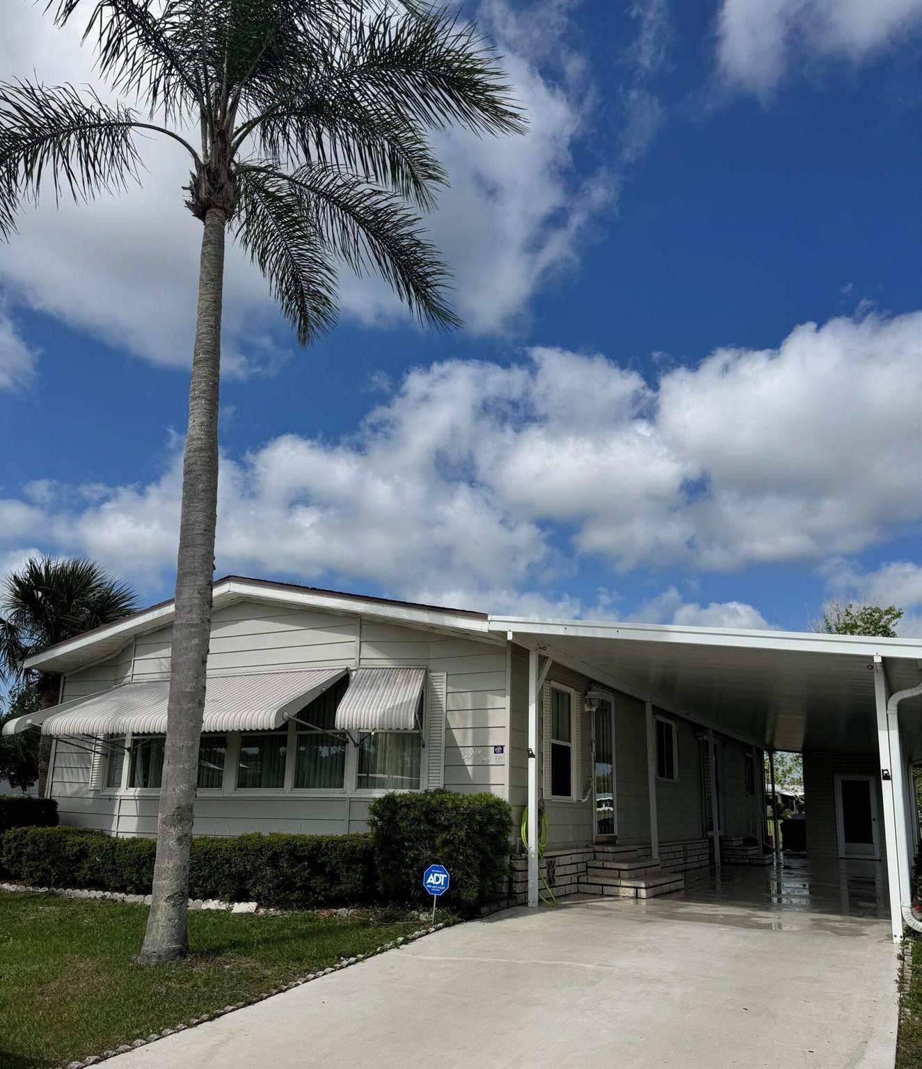 Well maintained 2 bedroom 2 bath lake view home. patio off back perfect for grilling or sitting to watch sunset. Home sits on a large corner lot. Home has open kitchen with island. The laundry room is inside home. Extra long carport. Home is being sold furnished. Water heater 2022 Spanish Lakes is a 55+ community. Lawn care, trash removal, golf included in lot rent. 2 pools, tennis, pickleball, bocceball, shuffle board. club house and much more. PRICED TO SELL!