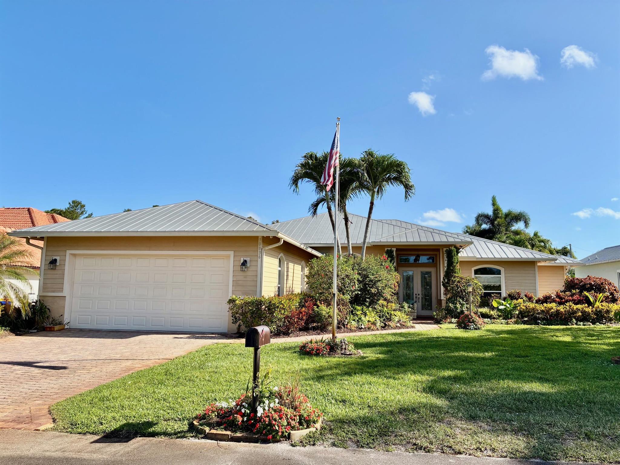 On the edge of Tequesta, find a private Coastal Sanctuary tucked away on a quiet street dead ending at the untouched beauty of Jonathan Dickinson State Park. This custom concrete-built home offers the perfect blend of natural serenity and comfort. Designed with an open-concept layout and soaring volume ceilings throughout, the interior feels expansive and airy. A standing seam metal roof, paver driveway and patio, and lush native landscaping create timeless curb appeal, while a screened pool and spa area invite you to relax and soak in the tranquil surroundings. Wildlife lovers will appreciate the abundant Florida birds, deer and other native species that frequent the area. A rarely used  quaint park with basketball court is just across the street
