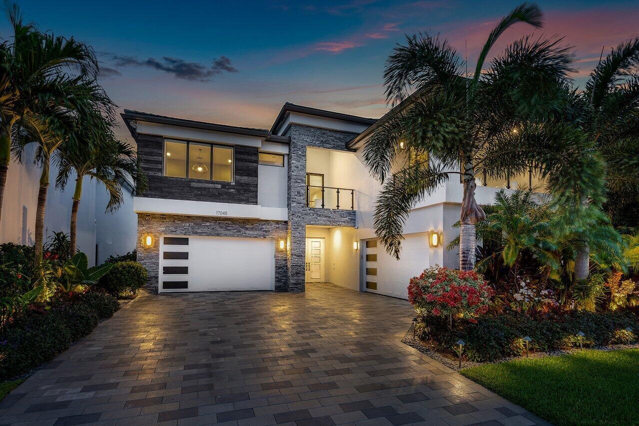You are going to fall in love with this stunning lakefront 6 bedroom, 8 bathroom, 4 car garage estate in the highly sought after community of Lotus. This Maldives model with premium elevation is nestled on a fantastic lot with a long sparkling lake views. The owners spared no expense when designing this home with over $900,000 in upgrades. The exterior was just professionally landscaped with elegant trees and plantings accompanied by designer outdoor lighting. The exterior is set up for the true Florida lifestyle as it offers a beautiful saltwater pool with 10' feature wall with shear descent, a infinity edge spa with a natural gas heater. Please click the supplement link for a full description... The estate also offers outdoor speakers, an 8"x16"open veranda and balcony, with the balcony offering a glass railing and both have electric motorized screens, a summer kitchen, and a whole house natural gas generator! This home provides the ultimate outdoor setting.


As you walk through the modern front doors you will be in awe of the updated floor plan. You have a beautiful open foyer with soaring ceilings and a designer chandelier. As you continue past the foyer you have a modern see-through wine room that holds 40 bottles, has custom LED lighting, and a floating cabinet with a light up quartz countertop. Adjacent to the wine room is an impressive spacious formal dining room overlooking the atrium with is a green wall by Vistafolia. Next you enter the huge family room with a custom wall feature including a see through steam fireplace. On the other side of the fireplace is a club room / game room with reflective vellum ceilings. Off the club room the owners added a luxurious cabana bath. Overlooking the family room and breakfast room is the chef's kitchen. The kitchen offers 3" waterfall quartz countertops with a full backsplash. two toned designer "fly-over" lift-up cabinets, a 48" Subzero refrigerator, and a Bosch dishwasher. The rest of the appliances are Wolf which include a 36" gas cooktop, wall oven / microwave, single oven, and hood. The kitchen is truly spectacular. The downstairs also features a guest bedroom and en-suite bathroom, and a separate powder room off the foyer for convenience. The custom flooring downstairs is incredible as it is 30"x60" imported tile. To complement the impressive downstairs you have two separate, two car garages, each with custom cabinetry, epoxy floors, a refrigerator, added storage access space under stairs w/ modern barn door, two Tesla Level 2 charging stations (1 in each garage, independently wired), and Garage doors each w/keypad entry panel and MyQ Smart Garage Door system. 


As you walk up the glass staircase, you will be presented with a massive upstairs living area with it's own balcony and wood paneled wall overlooking the lake and backyard. The entire upstairs has engineered wide plank French oak wood floors. Upstairs you have 4 more generously sized bedrooms, all with en-suite bathrooms, with one being a custom built office. You also have a media room (which can be converted to the 6th bedroom). The media room is complete with theater style seating on a raised platform, sound dampening carpet and added sound insulation, 86" LG TV, custom built cabinetry with refrigerator and microwave, 7 speakers and 2 subwoofers, and two motorized shades on the window, 1 is for blackout and one is for daylight. The upstairs primary is chic, elegant and overlooks the lake and pool. Off the master you have two large custom fit walk in closets. The primary bathroom is amazing and offers a free standing tub, imported cabinetry with large drawers, a stacked built-in linen cabinet, titanium fixtures, and a huge shower with a rain fixture, and 4 body jets. The upstairs living area is complimented with a nicely equipped laundry room next to the bedrooms. 


As previously mentioned, the owners spared no expense in upgrading this estate. Some of the upgrades not previously mentioned include: modern garage doors with impact glass windows, impact glass throughout, all exterior hurricane rated doors, motorized shades in every room, upgraded rolled insulation, energy efficient 75 gallon natural gas hot water heater, six Wi-FI access points, technology closet for internet, speaker access, and network wiring to every room, speakers in the common living areas upstairs and downstairs, 3" quartz countertops, upgraded fixtures and toilets in all bathrooms, upgraded Carrier Infinity air conditioning units with variable speed, solid core doors throughout, 6 security cameras and 3 House Alarm panels QOLSYS IQ2.
It doesn't get more turn key than this. Move right into pure luxury! This may be the nicest home in Lotus. Don't miss out on this opportunity. 


The guard gated community of Lotus has it all. The Club at Lotus offers a full service restaurant and bar, has indoor and outdoor dining, multiple resort like pools, fitness center, clubhouse, arcade, kids playground, indoor and outdoor basketball courts, tennis and pickleball. Living in Lotus is like living on a resort. You are also close to Boca and Delray's dining and entertainment! If you are looking for good schools, you will be delighted with the 3 A rated schools the property is zoned for.