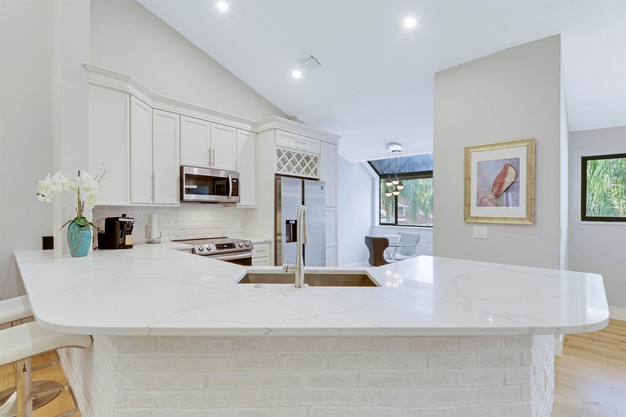 Enjoy paradise in this beautiful contemporary 2bedroom/2bathroom condo with one car garage at highly desirable community in Juno Beach. This spectacular home has been completely remodeled with beautiful upgrades and all the modern luxury comforts. Hardwood floors and ceramic tile throughout the unit. Large living area with vaulted ceiling leads to the kitchen and breakfast nook. Decorative custom molding on top of kitchen cabinets. White Tundra Brick around outside of kitchen island area. In addition a separate dining space. The gourmet kitchen features stainless steel appliances and quartz counter tops. Motorized black out blinds in Master and Guest Bedrooms for better sleeping and privacy.  Hurricane Windows installed throughout the unit. Laundry custom cabinets with heavier solid core doors. Custom glass staircase. AC was moved to attic and instead custom bar was built with wine fridge. New master and guest bathrooms with recessed mirrors. All new fans and dimmers throughout the unit. Patio area was added to the living space under AC.  Custom bench area entering from garage. New PEX pluming installed in 2023. New tankless hot water heater. 100% complete custom renovation. A rated schools. Walking/biking distance to pristine beaches, Juno Beach Pier, shopping &amp; restaurants. Common Pool &amp; Tennis courts in the community.