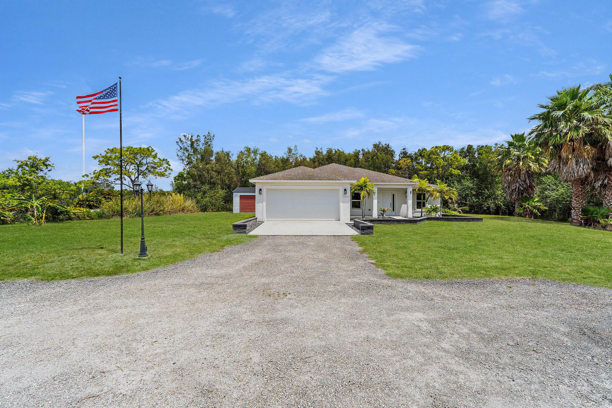 Exceptional opportunity to own one of the newer homes in 'Loxahatchee'. Constructed in 2020, this ranch style home is cited on a 1.37-acre lot. Thoughtfully designed, the split floor plan offers four bedrooms + den. Located at the end of a quiet street and lushly landscaped, this property offers the best in privacy.Design elements include Impact Windows, plank tile flooring, and an open chef's kitchen with white shaker cabinets and SS appliances. Towards the rear of the property, there is a 600+/- SF detached gym. Fully built out, including the gym equipment and TV's which will be left for the Buyer.