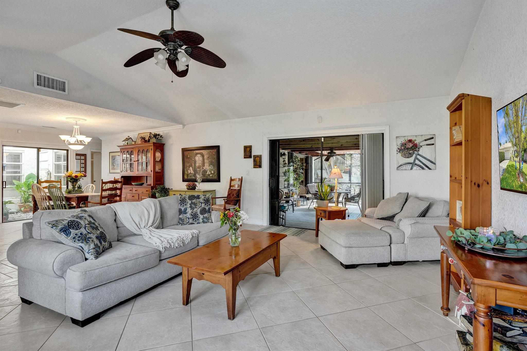 Tucked away at the end of a quiet cul-de-sac, this rare end-unit courtyard villa offers added privacy with a spacious yard and a peaceful grassy area maintained by the community. Just steps from the hidden shortcut  to the Red Bridge a beloved local landmark. This 3-bedroom, 2-bathroom home features a private atrium, vaulted ceilings, and a two-car garage. The covered, screened-in patio sits beneath a majestic banyan tree, perfect for relaxing or entertaining. Ideally located near the beach and moments from Boca's top shopping and dining, this villa blends elegance, convenience, and tranquility.