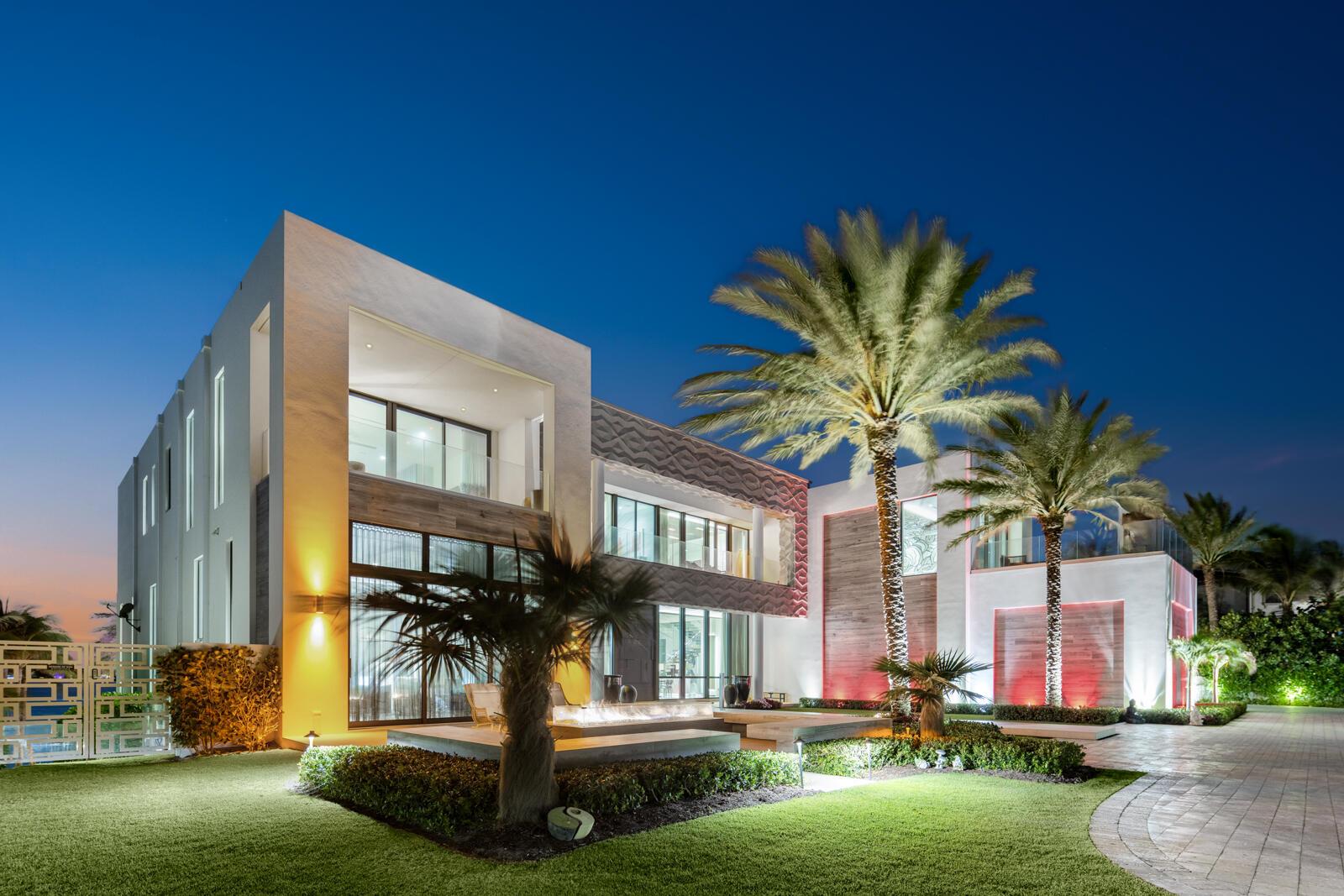 1940 South Ocean Blvd, Manalapan, FL 33462 - An Estate That Captures The Grandeur And Sophistication Of The World's Finest Luxury Hotel. Offered For The First Time, A Three Story 23K SqFt One-Of-A-Kind, Custom Built, Contemporary Seaside Masterpiece Stands Majestically Overlooking Nearly Two Acres Of The Florida Intracoastal Waterway And The Powdered Sand Shores Of Manalapan's Atlantic Ocean - Home To The Uber-Wealthy And Just South Of Americas Winter White House, ''Mar-A-Lago''. This Property Has Been Crafted From The Finest, Most Luxurious Resources, Fabrics, Stones And Natural Materials Available: Tunnel To Private Beachfront Cabana, Private Dock, Two Bowling Allies, Wellness Spa, Steam Room, Massage Room, Fitness Center, Movie Theater, Game Room, Craft Room, Elevator, Scullery Kitchen Personifying the spirit of relaxed elegance, this extraordinary gated, sun-drenched, three story, five bedroom, thirteen bath family home replete with underground tunnel to the 1,200 square foot beachside cabana with accompanying oversized lawns and Oceanfront balcony (the largest in Manalapan) stretches 150 feet across both the Ocean and Intracoastal Waterway, presenting nautical influences that suggest a breezy and serene palette - encompassing the essence of modern sophistication and coastal life. The underground tunnel offers a unique architectural feature, flawlessly connecting the main house to the lavishly appointed beachfront cabana. It ensures privacy and ease of access, making it convenient to enjoy the sun-drenched beach without stepping outside the boundaries of the estate. 

The Homeowners' natural flair for comfort was paramount when choosing each design element personally as the estates natural light and soothing aquatic tones of blues, grays, and sand invite a sense of peacefulness and balance, while blending the use of artisan hand-crafted tile work, marble, onyx, wood, metal, stone and glass along with the overhead glow from dramatic lighting fixtures in every room (each an individual work of art) add a heightened emotion of excitement. Each room boasts custom-built furniture that complements the architectural brilliance, creating a consistent yet vibrant visual narrative. The use of floor-to-ceiling windows throughout the home allows for an abundance of natural light to pour into every corner, creating a warm and inviting atmosphere. This thoughtful integration of natural light not only enhances the visible appeal but also contributes to the energy efficiency of the home. The interplay of light and shadow changes during the course of the day through custom fitted remote controlled black-out shades and sheer window treatments that follow the sun's path. The design elements of this home embrace a unique seaside escape, celebrating a way of life that treasures the beauty and tranquility of the coast - letting the soothing rhythms of the Ocean and the Intracoastal Waterway inspire you as you flawlessly and seamlessly move from room to capacious room without any interruption in style or mood.  

Upon entering this stately home through the grand oversized blue door, one floats like a dream past the open floor-plans formal dining room and luxuriously appointed living room and is immediately greeted by four 14-foot floor to ceiling limestone encased artistic wave design etched columns with accented lighting features there to remind you that the soothing Atlantic Oceans' surf is mere steps away. You can arrive in elegance to any of the homes three levels by either marble encased elevator boasting Intracoastal views through glass walls or a stylish cantilever wood staircase with marble and glass accents. To the south hall is a dramatic full-service backlit onyx bar flanked between twin rare and semi-precious lapis lazuli stone columns that create not only a striking focal point but also symbolizes a bridge between the earthly and the divine with elegance and artistry. A glass enclosed one thousand bottle temperature-controlled wine room and adjoining waterfront club room with its "11 Ravens" billiard table, bespoke design and meticulous craftsmanship makes this sophisticated space perfect for socializing and relaxation, inviting guests to unwind in elegant waters-view surroundings. Directly to the east one enters through glass encased sliding doors to the "Gentlemen's Office" displaying verdant views of the porte-cochere, front lawn and Ocean facing lounging area replete with glass fire-pit. Completing the middle / Ocean level, the gourmet kitchen with adjacent full service scullery kitchen equipped with state-of-the-art appliances and an abundance of custom commissioned sleek cabinetry seamlessly transition into multiple family and formal dining areas as well as the large west facing family room with outdoor covered loggia / grilling area using the Intracoastal Waterway as the  perfect scenic backdrop.

Spanning a sizable portion of the third floor, the oversized Homeowner's suite is a sanctuary of calmness, opulence and tranquility. This grand suite boasts breathtaking views of both the Atlantic Ocean and the Intracoastal Waterway. The suite features an expansive bedroom area adorned with luxurious custom furniture, including plush sofas, oversized chairs, cozy couches, marbled walls, wood floors and serving as the rooms' main focal point amidst all the lavish fabrics is a floor to ceiling custom crafted hide wall that carries onto the ceiling and down to a fireplace. The elegant design incorporates floor-to-ceiling windows that invite natural light to flood the space, creating a serene and inviting atmosphere. The individual his and her bathrooms within the suite are a masterpiece of design, exotic materials and comfort, equipped with a waterfront view freestanding sculpted soaking tub, multi-jetted showers, and expansive vanity areas adorned with jewel quality finishes. The use of high-end materials such as marble, onyx, and artisanal woodwork elevates the space, providing a moody spa-like experience. Adjacent to the bathrooms are three extremely generous sized, boutique-quality walk-in closets featuring custom-built cabinetry that provide ample space for a vast wardrobe. The suite also includes a private Oceanfront sitting room, perfect for relaxation. Flanking the east and west positions of the primary suite, sliding glass doors seamlessly flow onto the twin "Homeowners' Access Only" outdoor spaces where balconies, outdoor showers, and private hot tub await, perfect for enjoying picturesque Florida sunrises or sunsets. Continuing down the hall, the three additional guest bedrooms are adorned with en-suite bathrooms, plush bedding, custom-built furnishings, exotic stone counters, tiled or fabric walls, and expansive windows and balconies in each room that frame stunning views of either the Ocean or Intracoastal Waterway as well as the estate's lush surroundings. 

Upon entering the estate's entertainment and wellness lower level, immediately your senses are heightened by the unparalleled luxury, entertainment features and scenic Intracoastal views that surround you designed to elevate your living experience. The meticulously designed space boasts an array of amenities aimed at providing the utmost in relaxation and enjoyment. The lower level features a high-end Zen spa atmosphere complete with massage room, steam room, soothing multi-jetted showers with adjoining warm hued wood lockers providing a sanctuary for relaxation and rejuvenation; a state-of-the-art fitness center, equipped with the latest exercise machines promotes one's physical well-being, allowing you to maintain your physical health in style. A dedicated craft / hobby room (that can easily be converted into a sixth bedroom, if necessary, as it is fitted with its' own private en-suite bath). For those who appreciate indoor action-packed activities, the estate also offers a mind-blowing, one-of-a-kind two-lane bowling alley offering the most unique recreational experience; a movie theater complete with plush seating and state-of-the-art audio-visual equipment, promising an unparalleled cinematic experience; a game room complete with full service indoor-outdoor waterfront bar equipped with the latest entertainment systems and large screen and projection video monitors - all providing endless fun for family and guests alike. The multi-level outdoor entertaining and pool area is a true oasis, designed to host unforgettable gatherings amidst a backdrop of natural beauty and luxury equipped with a full-service bar. The expansive outdoor space features a stunning tiled infinity pool and submerged spa that seems to join seamlessly with the Intracoastal Waterway, creating an illusion of unending water views. Surrounding the pool are multiple lounge areas with plush seating, perfec