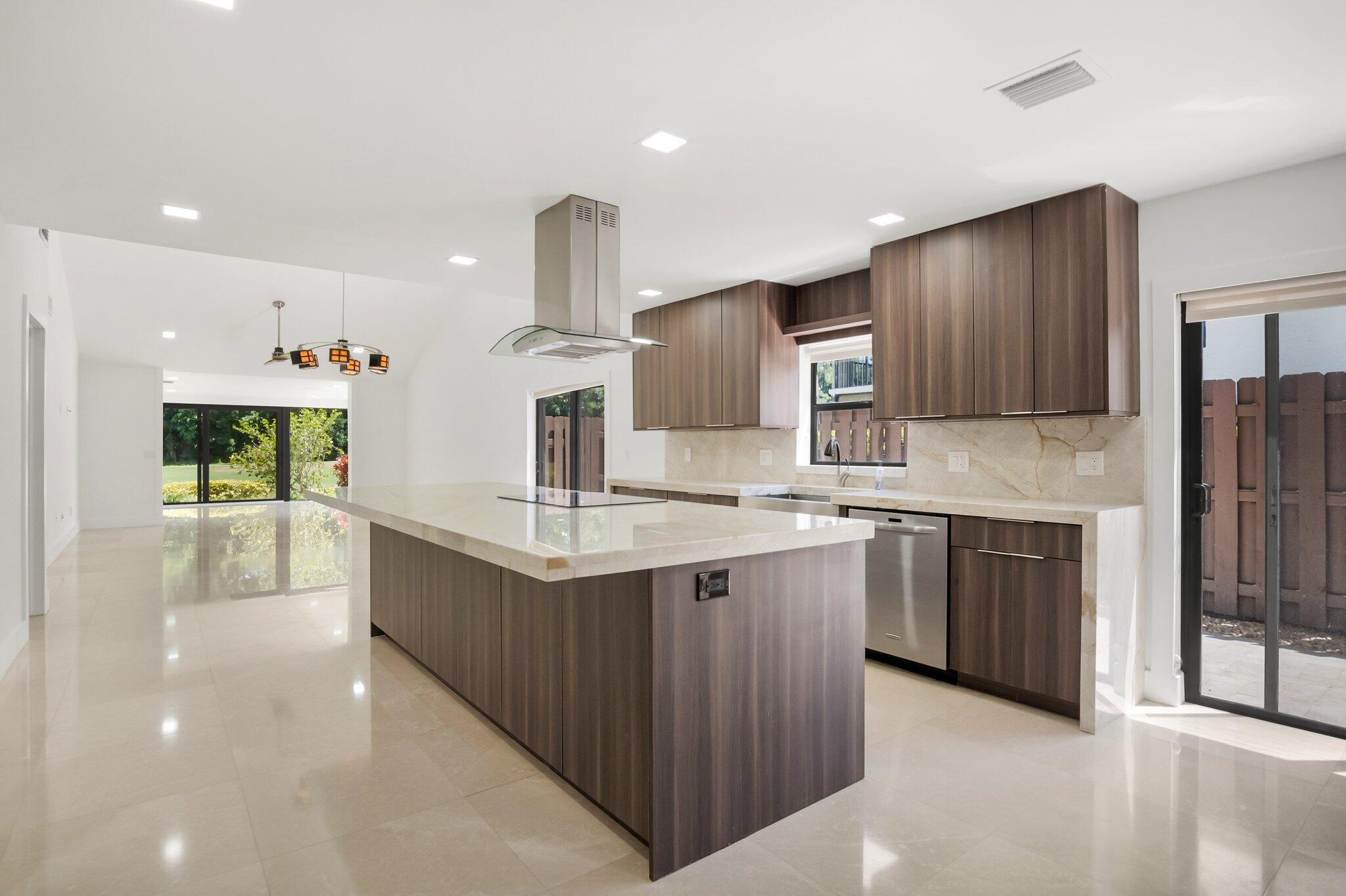 This remodeled one-story villa is a must-see. It's been completely redone, featuring Travertine floors throughout. The enclosed patio has be fully incorporated into the main living area and all openings have been replaced with hurricane windows. Automatic and remote-controlled window treatments, Built-in bar with a wine cooler all appliances, including the AC, tankless water heater, ceiling fans, and everything else, are modern and state of the art. The kitchen has a large quartz counter island with loads drawers and cabinets. redesigned laundry room with cabinets and a countertop. Re imagined bathrooms and the master bath is set up for two. Totally fitted out closets  The unit has a new roof.  This home could not duplicated at this price.