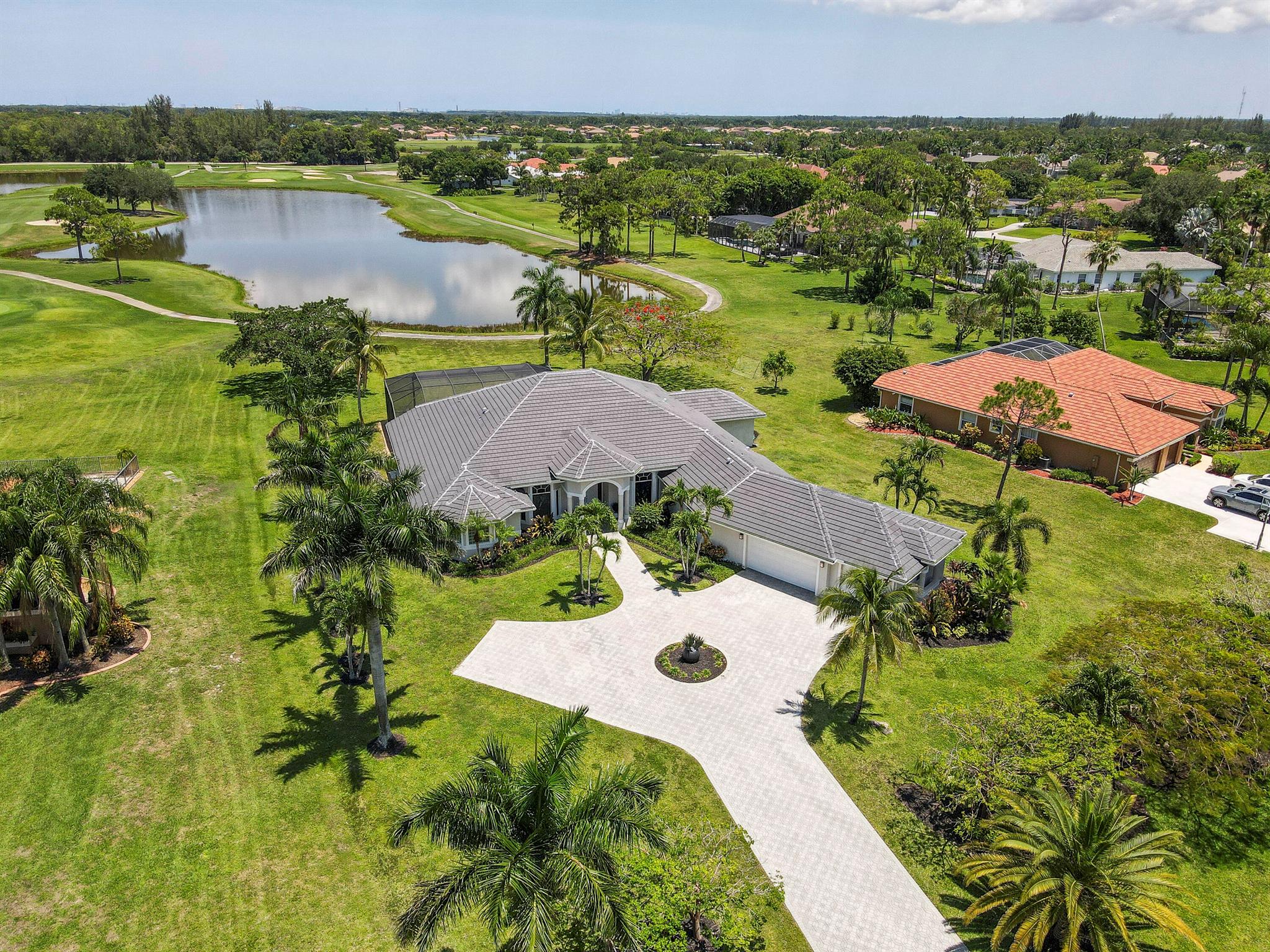 Enjoy the BEST WATER VIEW in Bay Hill Estates from this single-story home set on a full 1-acre lot. With a 2023 roof, newer A/Cs, and a 2020 hurricane-rated screened lanai, this home blends peace of mind with luxury living. Inside, you'll find high ceilings, a split floor plan, and expansive windows and sliders that showcase the lake & golf course views. The kitchen offers white cabinetry, black granite, and a central island with double ovens. The extended primary suite features an elegant en-suite featuring double vanities, a soaking tub, and a walk-in shower. The lanai is spacious, screened, and equipped with a TV hookup, making it the perfect setting for al fresco evenings. Located in a guard-gated golf course community just minutes to the exciting new Avenir town center.