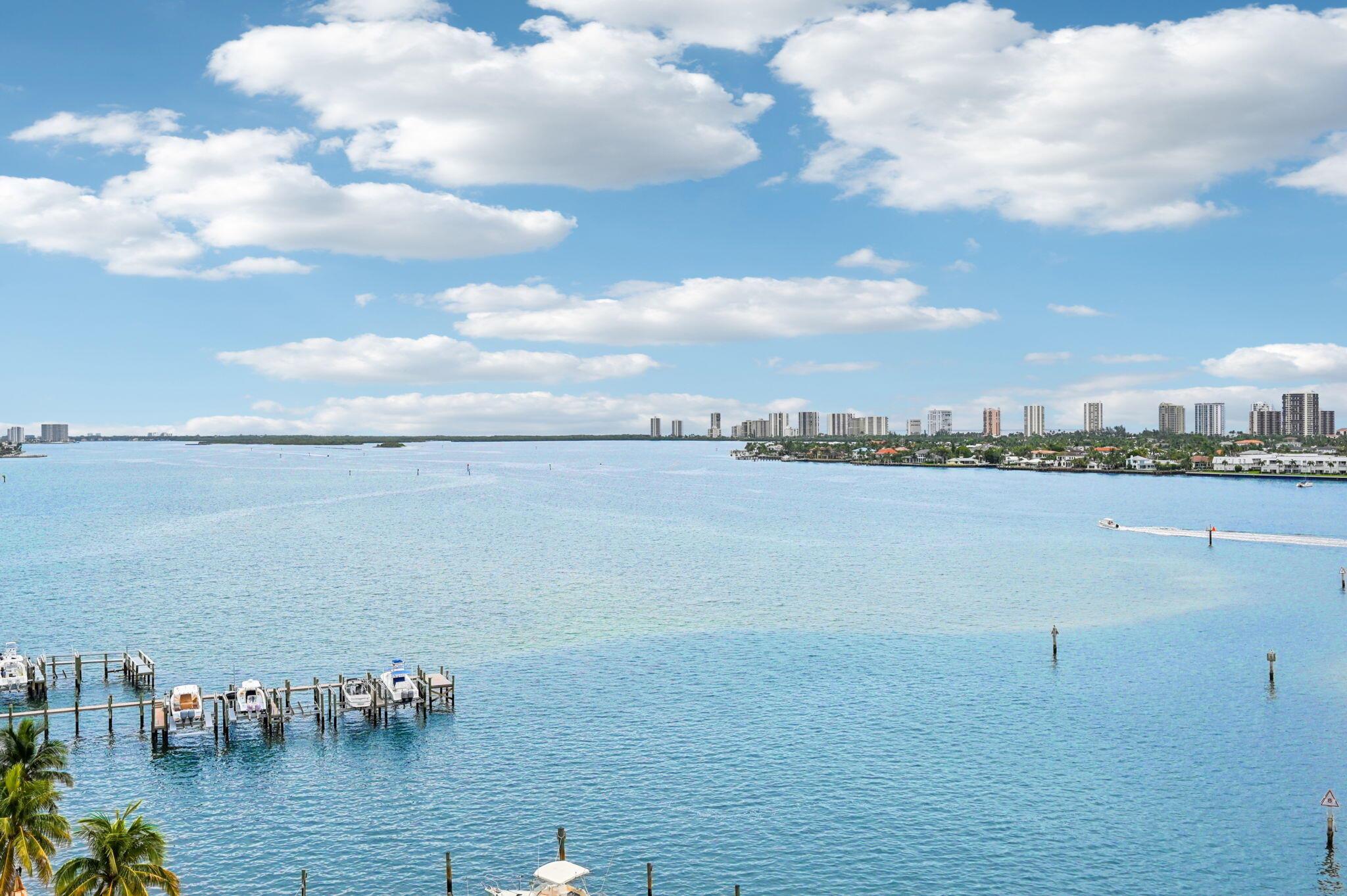 This highly sought-after 10th floor ''06'' unit offers 2,287 square feet of luxurious living space, featuring three bedrooms, three and a half bathrooms, and a versatile den. The residence boasts a massive wraparound balcony with breathtaking views of the Intracoastal Waterway, Atlantic Ocean, Singer Island, marina, and city lights. Floor-to-ceiling hurricane-impact glass spans 25 feet, enhancing the open, airy feel, complemented by custom flooring, built-in closets, and a newer A/C system. Residents enjoy resort-style amenities included in the HOA fees, such as a rooftop heated pool and sun deck, a waterside gazebo perfect for spotting dolphins and manatees, five grilling stations with shaded picnic areas, and courts for tennis, pickleball, and bocce. A state-of-the-art fitness center, stylish social room, 24/7 security, and valet parking add to the convenience, while cable, high-speed internet, and hot water are included.The location combines lifestyle and convenience with an adjacent marina ideal for boat owners, a Publix supermarket right across the street, and just five minutes to the beach and waterfront dining. The community is active year-round with social events, and nearby opportunities for kayaking, water sports, and fishing make it an ideal coastal retreat.