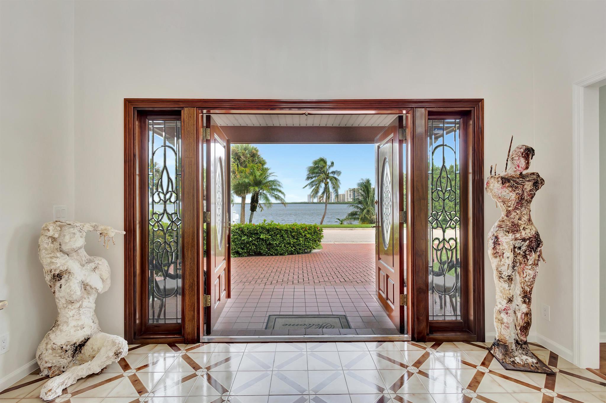 This is a home with a story. Built in 1977 and owned by one family ever since, 1141 Pine Point Rd sits on one of the most sought-after streets on Singer Island--with wide, unobstructed views of the Intracoastal and just a short walk to the beach. The layout is practical and spacious: 4 large bedrooms, 3 baths, with a full guest room on the main floor. Upstairs offers a true split plan--two guest rooms on one side, and a private owner's wing with its own sitting area and access to a full-length waterfront balcony. Every room was designed to capture a view, and the upstairs terrace is where you'll catch some of the most peaceful sunsets South Florida has to offer. Step into a double-height foyer with custom tilework and a grand staircase. The main level includes a formal living room, a family room, bright breakfast area, a full laundry room, and a detached garage studio perfect for a home office or gym. The circular driveway and handcrafted details give the home a quiet elegance that speaks for itself.
Out back, enjoy your own private oasis: a sparkling pool, fruit tree, and mature landscaping within a fully fenced yard. You can literally launch your kayak or paddleboard from across the street and enjoy direct access to the Intracoastal&#x14;watch manatees and marine life pass by from your patio.
This is not a spec build. It's a rare opportunity to own a timeless piece of Singer Island&#x14;solid, well cared for, and full of potential.