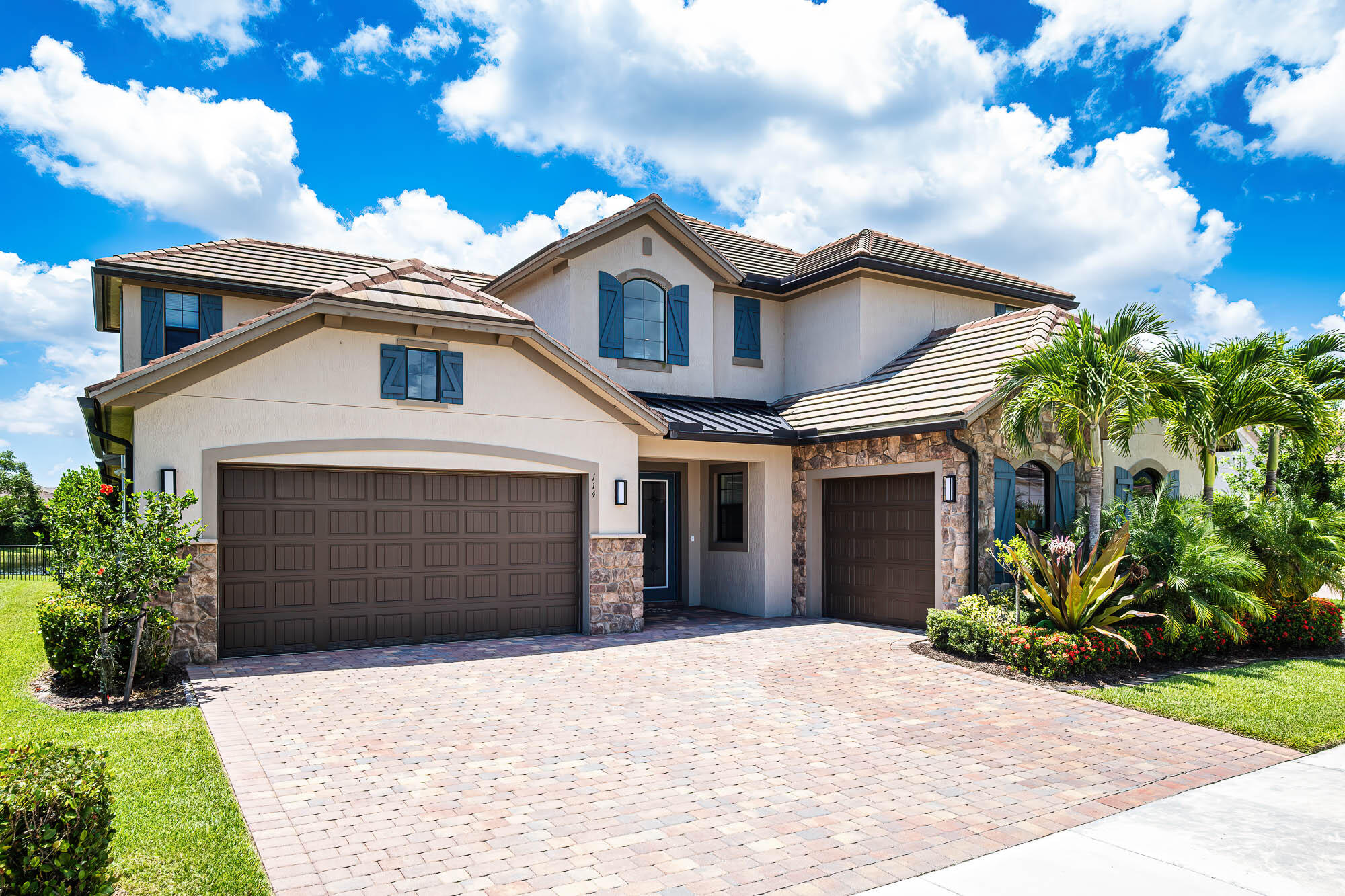 This lot was specifically selected for its highly desirable southern exposure and long lake view. The leaded glass doors of this exquisite 2-story home open to a stunning ornamental staircase and a spacious open floor plan filled with natural light. 5 bedrooms, and 5 1/2 baths. Perfect for generational families, the primary bedroom,  guest room, and office/flex space are downstairs, plus 2-separate garages. Enjoy the relaxing, long lake view from your pool and spa. The rear impact glass sliding doors open completely, expanding the living space into the screened lanai. Positioned on the western side of the community, this home benefits from its distance from the FL Turnpike and I-95. This is a spectacular place to call home. Don't miss this opportunity--schedule your private showing today.