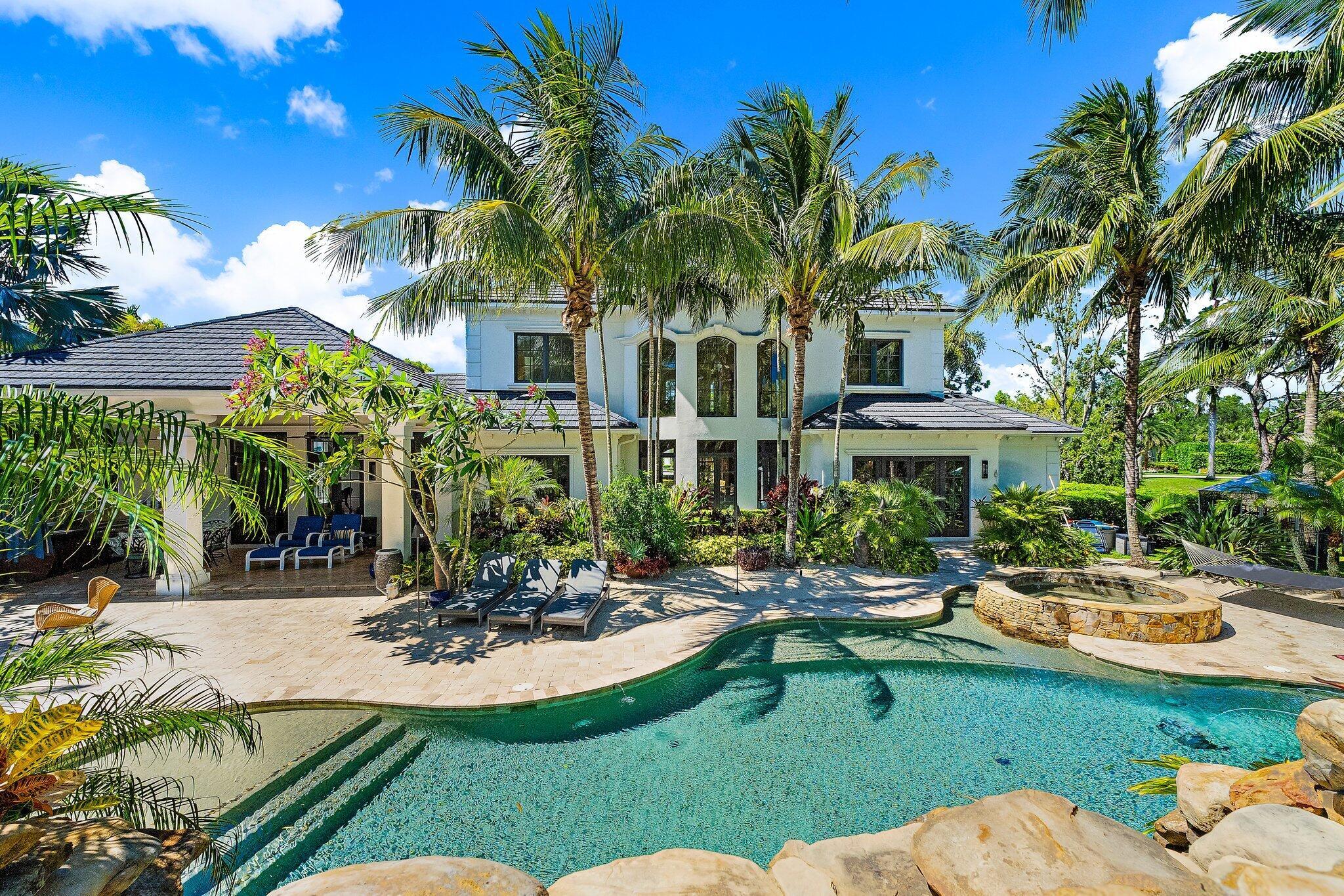 Live the resort lifestyle every day in this extraordinary custom estate in the gated community of Jupiter Equestrian Estates (Hidden Bridge). Set on a beautifully landscaped one-acre lot, this 5-bedroom, 5 full + 2 half bath home offers both luxury and comfort, with a thoughtful layout and incredible outdoor living spaces.The primary suite is located on the main floor and features separate his-and-her toilets for added privacy. Upstairs, you'll find four generously sized bedrooms, each with its own en-suite bath, plus a large bonus room perfect for a media space, gym, or playroom. The custom-designed office and chef's kitchena"with double islands, gas stove, and Viking appliancesa"make daily living and entertaining effortless. Step outside to your private tropical retreat with a lagoon-style pool, 20-foot slide, 12-foot waterfall, summer kitchen, and tranquil tiki hut sitting area. The entire yard is fully fenced and surrounded by lush landscaping, offering true serenity. Additional highlights include a whole-house generator, hurricane-impact windows and doors, and a 3-car garage.

Tucked away in an exclusive enclave of just 16 homes, this property is a rare opportunity to enjoy privacy, elegance, and the best of Jupiter living.