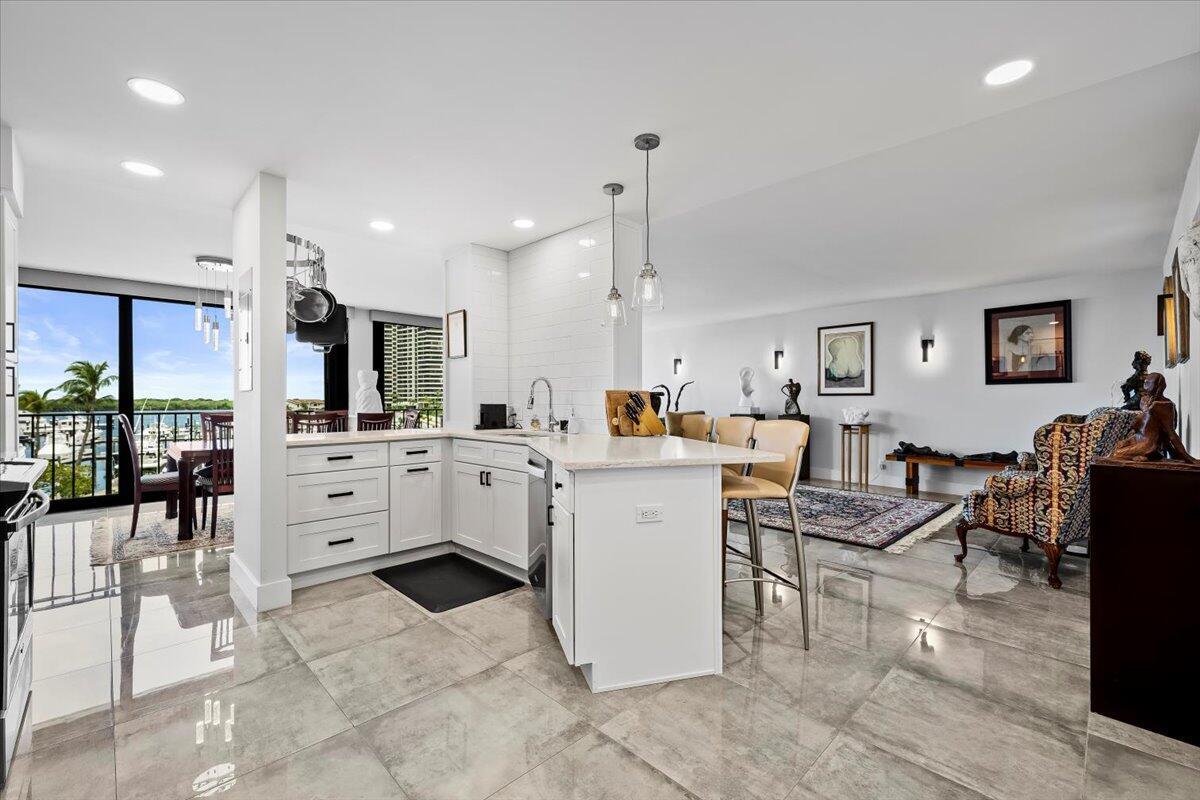Step into sophisticated coastal living with this entirely renovated 2-bedroom, 2-bath residence in the highly desirable Old Port Cove community. This thoughtfully updated unit features impact-rated (Low E) sliding glass doors, solid hurricane resistant front door, electric sunshades, NEW Air conditioning unit, and a NEW full sized washer/dyer (non-vented) unit that has been grandfathered in, offering the perfect blend of comfort and convenience.The enclosed balcony adds valuable additional living space, enhancing both the functionality and square footage of the home. Inside, enjoy an open-concept layout with high-end finishes, custom cabinetry, modern lighting, and updated flooring throughout.