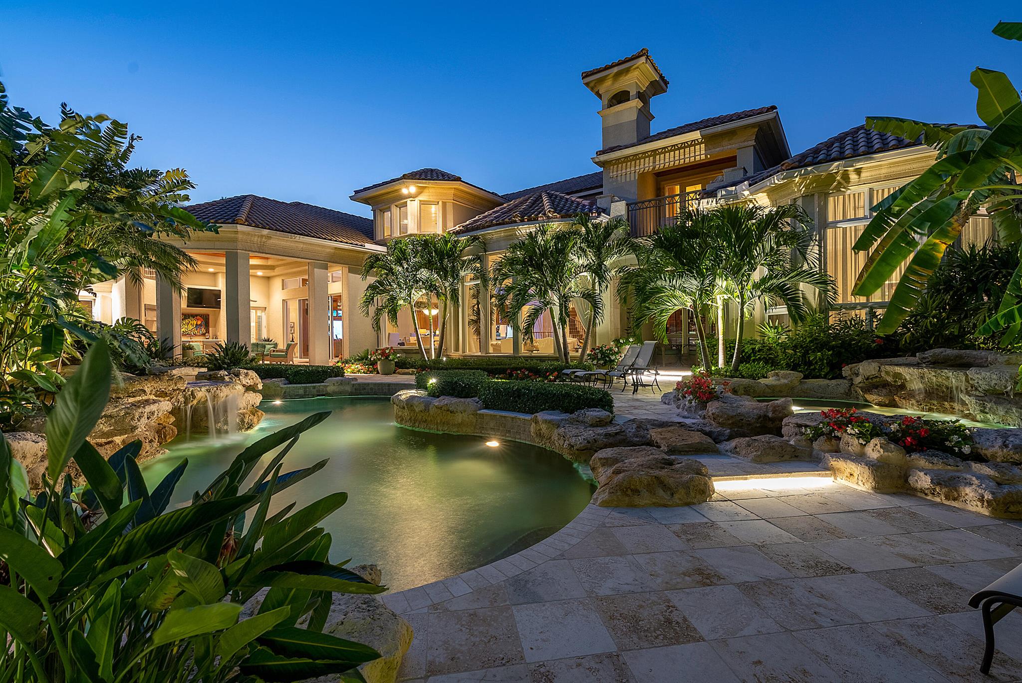 Immerse yourself in the unparalleled beauty of this exceptional waterfront estate, meticulously crafted in the prestigious Royal Palm Yacht & Country Club. With captivating waterway views, this bespoke residence offers a tropical oasis. Sprawling across an expansive 2.25 lots, encompassing over half an acre of lush greenery, and boasting an impressive 216 feet on the Buccaneer Palm Waterway, this architectural marvel designed by Randall Stofft promises an extraordinary living experience.Indulge in the enchanting ambiance of the meticulously landscaped grounds, where outdoor entertaining is elevated to an art form. Covered terraces invite you to savor the natural surroundings, while the multi-level pool and spa, thoughtfully positioned to embrace the southern exposure, provide the ultima retreat for relaxation.
Inside, curated interiors seamlessly blend with the picturesque backyard, perfectly complementing the open and flowing floor plan. The residence showcases five sumptuous bedroom suites, two offices, and a captivating library, all meticulously designed to meet the highest standards of luxury living.
Experience the epitome of luxury living in this exquisite waterfront estate, where every detail has been thoughtfully curated to provide an unparalleled lifestyle of elegance and refinement.
Buyer to pay documentary stamp taxes on the deed and title insurance. Furniture is negotiable.