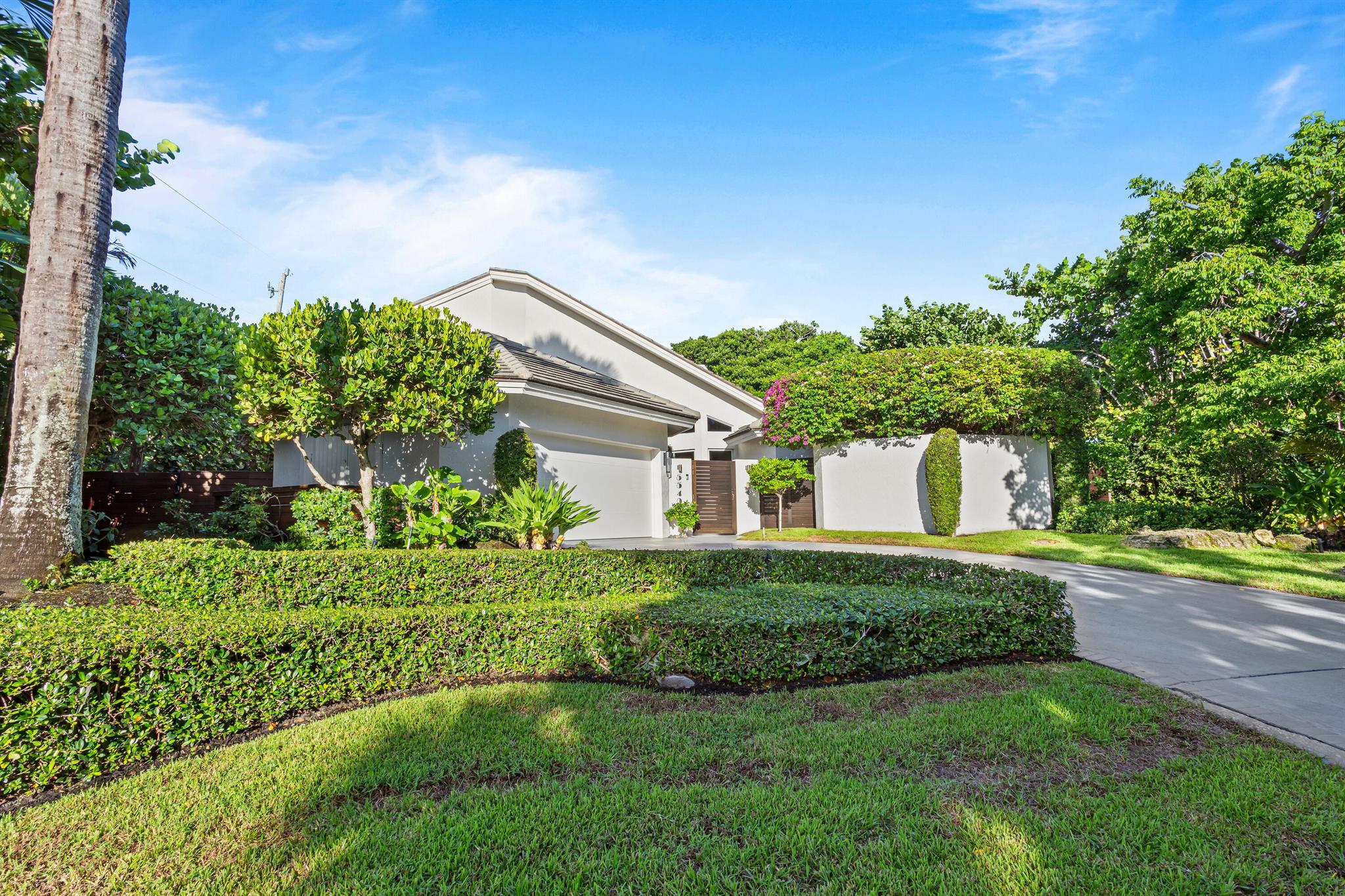 Lushly landscaped beach-area four-bedroom estate in prestigious Ocean Ridge is beautifully detailed with a modern vibe, a touch of Zen, and a sense of drama. Attractive details include dramatic soaring vaulted ceilings, polished Saturnia flooring, and a fireplace with a stone mantel. The lush tropical landscaping is enhanced by many new features, and this neighborhood has easy beach access.