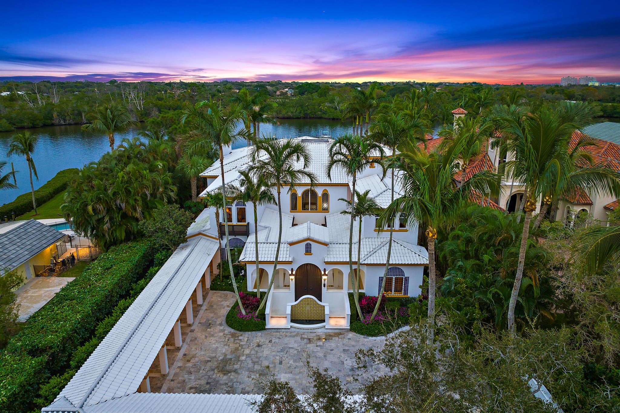 Extraordinary Intracostal Home For Sale in Palm Beach Gardens. Immerse yourself in the epitome of refined living, where every detail has been meticulously crafted to create a Moroccan-inspired haven. This 5 bedroom, 8 and a half bathroom home sits on .68 acres and is 7,175 sq ft under air (10,803 sq ft total). With direct access to the intracoastal, no fixed bridges, deep water, over 90 feet of direct waterfront, and a 120-foot dock, this home is well-equipped for the boat of your dreams. Jupiter & Palm Beach inlet less than 10 miles.  Remodeled in 2018, features include a newly added in-law suite, pool cabana, covered porch, balcony, an office, two boat lifts, a whole-home generator, brand new pool heater, and top of the line appliances from brands like Sub-Zero, Wolf, Jenn-Air, and Tru