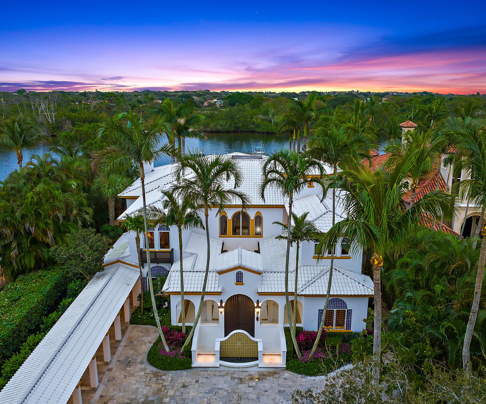 Extraordinary Intracostal Home For Sale in Palm Beach Gardens. Immerse yourself in the epitome of refined living, where every detail has been meticulously crafted to create a Moroccan-inspired haven. This 5 bedroom, 8 and a half bathroom home sits on .68 acres and is 7,175 sq ft under air (10,803 sq ft total). With direct access to the intracoastal, no fixed bridges, deep water, over 90 feet of direct waterfront, and a 120-foot dock, this home is well-equipped for the boat of your dreams. Jupiter & Palm Beach inlet less than 10 miles.  Remodeled in 2018, features include a newly added in-law suite, pool cabana, covered porch, balcony, an office, two boat lifts, a whole-home generator, brand new pool heater, and top of the line appliances from brands like Sub-Zero, Wolf, Jenn-Air, and Tru