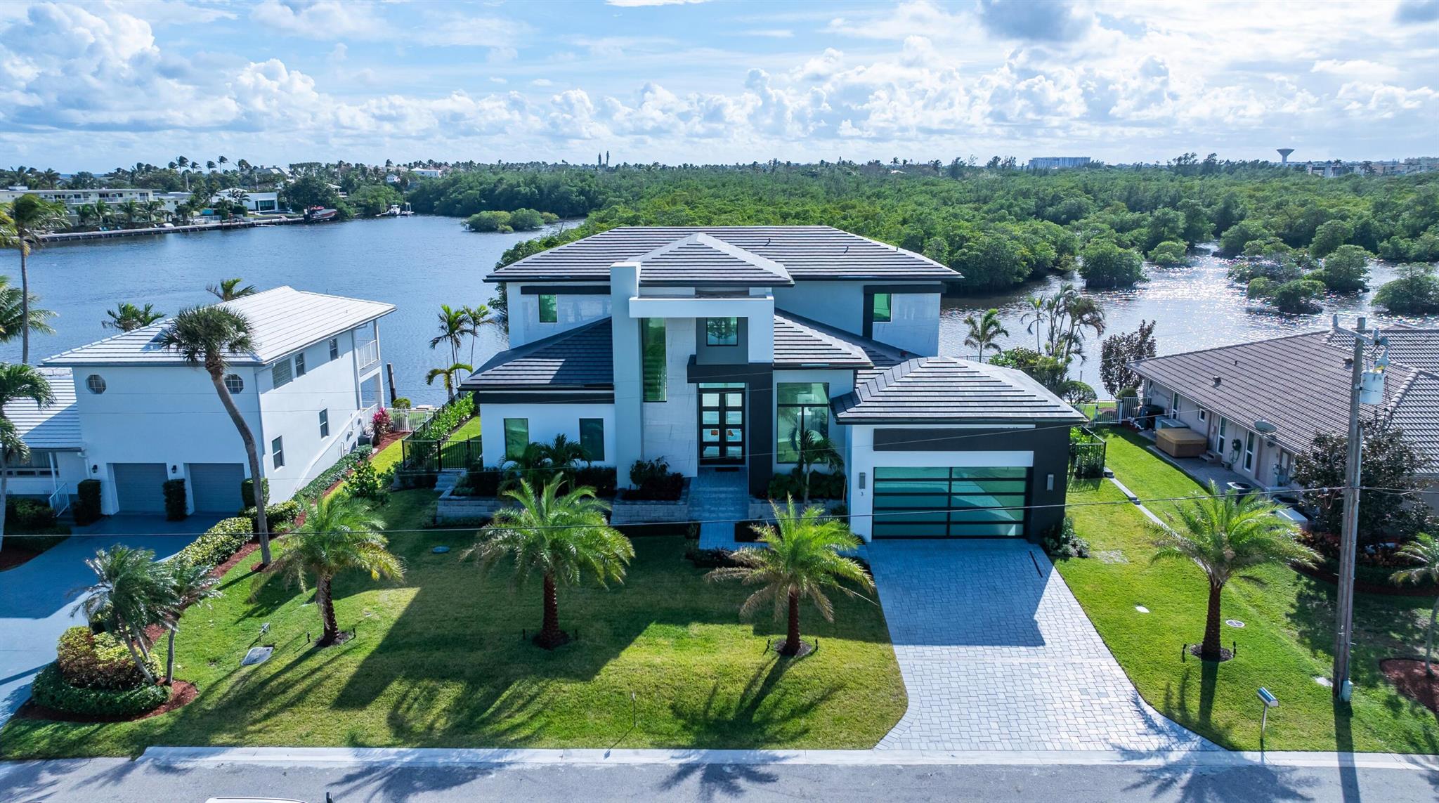Brand new construction modern estate, on an Intracoastal Waterway island, overlooks a veritable forest of mangroves on a protected pristine nature area owned by the Town of Ocean Ridge. With 100-feet on the water and a dock, boaters will enjoy unimpeded access to the ocean. Details include a great room with a bar, great chef's kitchen, first-floor primary suite and a second-floor VIP suite. RESIDENCE:

Designed by Boca Raton architect Richard Bremer and just completed this year, with four bedrooms plus an office and 5,407 +/- total square feet, this stunning Modern estate, clad in stucco and highlighted by stone, offers the ultimate for indoor/outdoor waterfront living. Its well-conceived open-layout, split-bedroom plan  accommodates views of the water, nature area and a verdant stand of mangroves from every room. Immediately from the entry, one is transfixed. Elegant, chic, and exceedingly relaxing, details include high ceilings, window-walls of glass bathing the interiors in soft sunlight, large-format Italian porcelain flooring downstairs and engineered hardwood flooring upstairs. The two-story foyer and staircase introduce the great room, featuring a wet bar perfect for entertaining, and banks of glass sliding doors open to the poolside lanai blurring the boundary between inside and out. Just adjacent is the double-island chef's kitchen, which is fitted with handsome Shaker-style cabinetry accommodating copious storage, an artistic tile backsplash set in a herringbone pattern, and professional-grade Thermador stainless-steel appliances. The serene first-floor primary suite, set apart for privacy, comprises a spacious bedroom with sliding doors opening to the pool patio and offering water views, double custom-fitted walk-in closets and a spa-inspired bathroom with duo vanities, oversized walk-in glass-enclosed shower and a free-standing Jacuzzi tub. Upstairs, The VIP suite and two guest bedroom suites all open to the water-view balcony, with one of the guest bedrooms currently serving as an inviting club room. Completing the layout are an office, powder room, cabana bath, laundry room and two-car garage with space for car lifts.

PROPERTY:

Homeowners of this amazing estate enjoy incredible and unique views. On an Intracoastal Waterway island, the estate's south-facing fenced back yard overlooks the canal to a veritable forest of mangroves on a protected pristine nature area owned by the Town of Ocean Ridge. The treasured refuge is home a variety of Florida wildlife, a true wonder for nature lovers. Here, homeowners will also enjoy a fabulous indoor/outdoor lifestyle. The covered lanai, with a summer kitchen and grill, is just adjacent to the sun-splashed pool that integrates a sun shelf and infinity spa, set within an expansive patio. And that is not all. With a dock and 100 feet on a canal that adjoins the Intracoastal, boaters will enjoy easy ocean access with no fixed bridges.

LOCATION:

Inlet Cay Drive, Ocean Ridge, Florida. One of the Gold Coast's best-kept secrets, exclusive Ocean Ridge is prized for its quiet solitude, relaxed ambiance and unspoiled landscape nestled between the Atlantic Ocean and the Intracoastal Waterway.