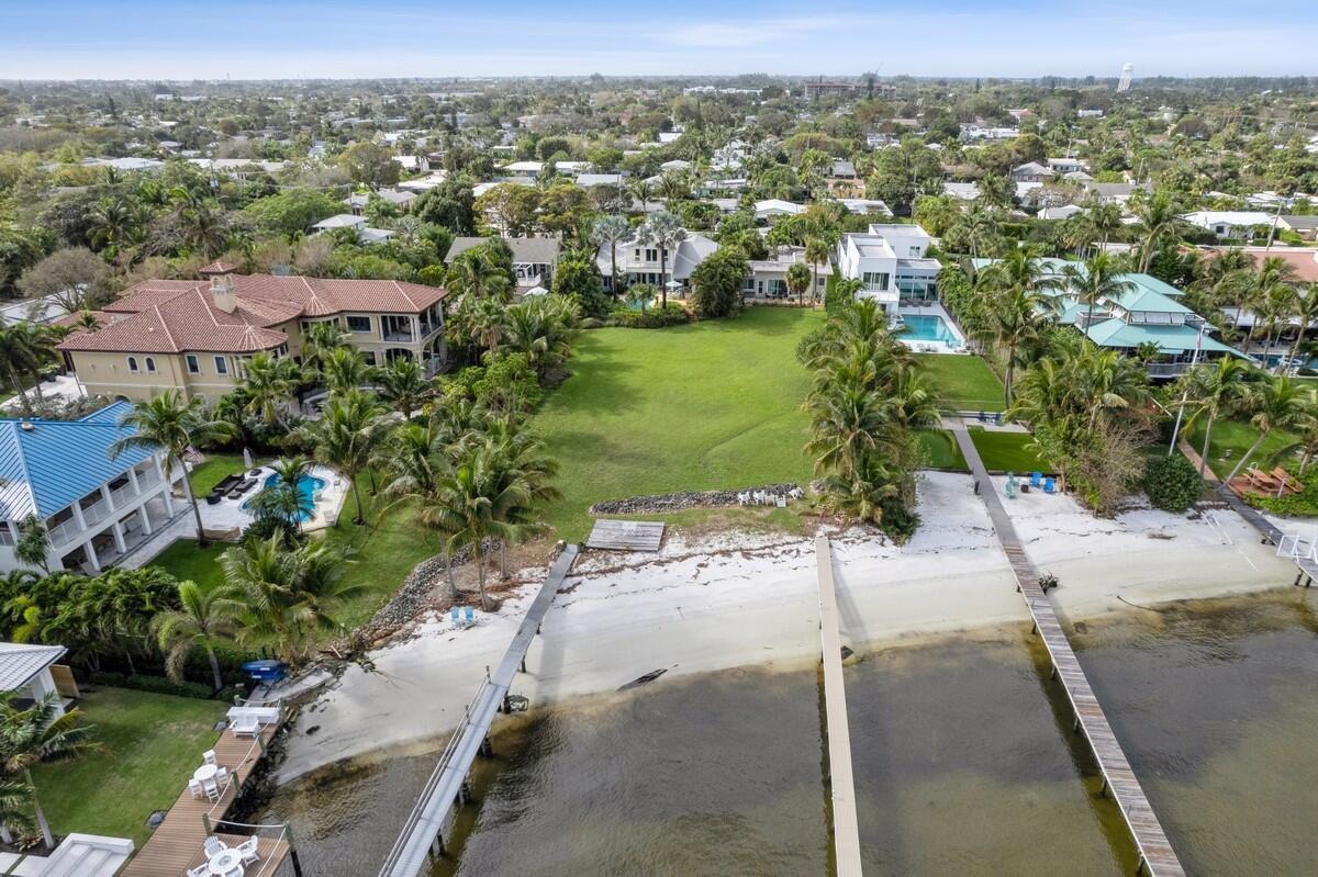 Intracoastal property includes private dock and beach! This charming Key West style dream home - sits on a gorgeous supersized large lot with vast intracoastal views of the Lake and Palm Beach. This 3 bedroom, 4 bath home comes with generously sized downstairs and upstairs primary suites, two balconies, covered patio by the tropically landscaped heated pool. Recently updated new kitchen and bathrooms with a circular drive and a large 2 car garage with tons of storage. The white sandy beach leads out to the 300 + foot private dock for the yacht of your dreams. Lot size is approx.  70'x 362'.