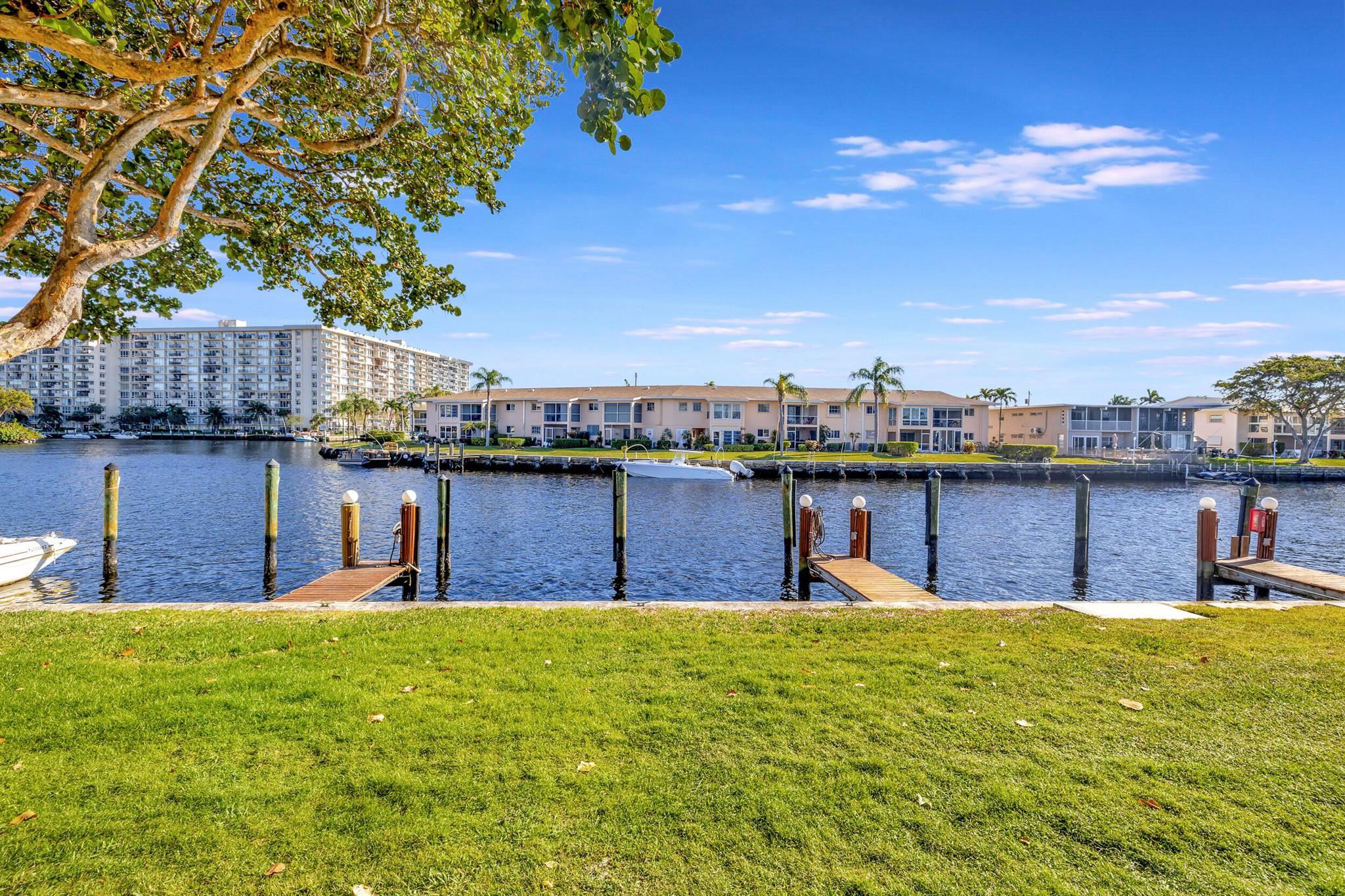 Welcome home to Noble Point, an unparalleled boaters dream of a small gated waterfront community.  Your assigned boat dock with water, electric and lighting is directly behind this ground floor Deluxe Model (only 11 of these large units in the complex). The Premium Southern Exposure and Extensive backyard lawn all overlooking the wide water basin views add to the charm of this rarely available condo. Besides the private dock you have covered parking for your land toy as well! A true hidden gem of a complex has a heated/cooled pool, clubhouse, hot tub, tennis/pickle ball courts and a great tiki hut BBQ area. Outside there is a Large screened patio for ultimate SoFlo living, inside features hard wood floors and neutral colors making this one a must see!  Private Dockage for your large Boat!