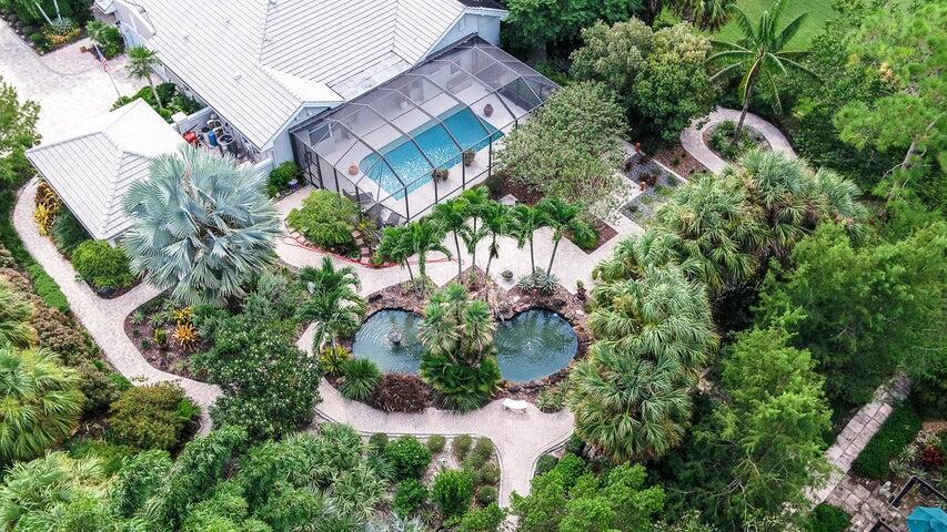 Wow! You will think that you are living in the botanical gardens with these lushly landscaped & tropical grounds featuring walking paths, Koi pond with waterfall & trellis. This home will tantalize your tastebud's from room to room. Completely remodeled in 07 & 08' including newer roof and all impact windows & doors. The gourmet kitchen features top of the line SS appliances, 6 burner gas Wolfe cook top & sub zero refrigerator. Solid wood doors, cork floors in LR, MBR & library. Bamboo in BR's. Marble flooring in living area. No expense has been spared. All LED & Halogen lighting. Impact Mahogany & glass impact front doors. Spa like bathrooms, crown & chair rail moldings, plantation shutters adorn the interior. Propane gas whole house generator. Summer kitchen  heated pool & outdoor Showe