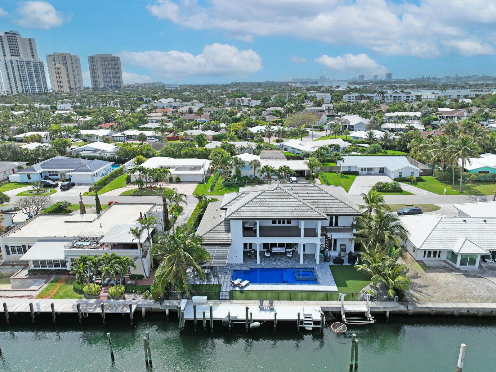 Built in 2019, this upgraded home sits on an expansive 11,000 sq ft intracoastal waterfront lot, fulfilling every boater's or water enthusiast's fantasy with 100' of waterfrontage, perfect for up to an 80' yacht thanks to the deep water and wide channel. Nestled on Bimini Lane, homes here offer deeded beach access. Step through grand oversized entry doors into a realm of opulence across an open floor plan. Gaze through rear sliding glass doors to behold your dream water vista beyond the pool and vanishing edge spa. This home boasts over 4,200 sq ft of AC living space and over 6,000 sq ft of total area, featuring 5 large BR'S and 5.5 BA'S. The first floor encompasses a master suite, formal dining area, laundry room, powder bath, and a private cabana suite with a large covered lanai. Ascend to the second floor via stairs or private elevator to find a secondary master suite, wet bar area, two guest suites, a media loft, covered lanai, and washer/dryer unit. Craftsmanship shines with high-end plumbing and electrical fixtures, a Sub-zero appliance package including an oversized refrigerator and natural gas cooktop in the kitchen. Revel in outdoor gatherings with the outdoor kitchen and natural gas grill. Full house generator! Experience award-winning craftsmanship and transform this residence into your personal sanctuary. Singer Island beckons as paradise awaits your arrival.